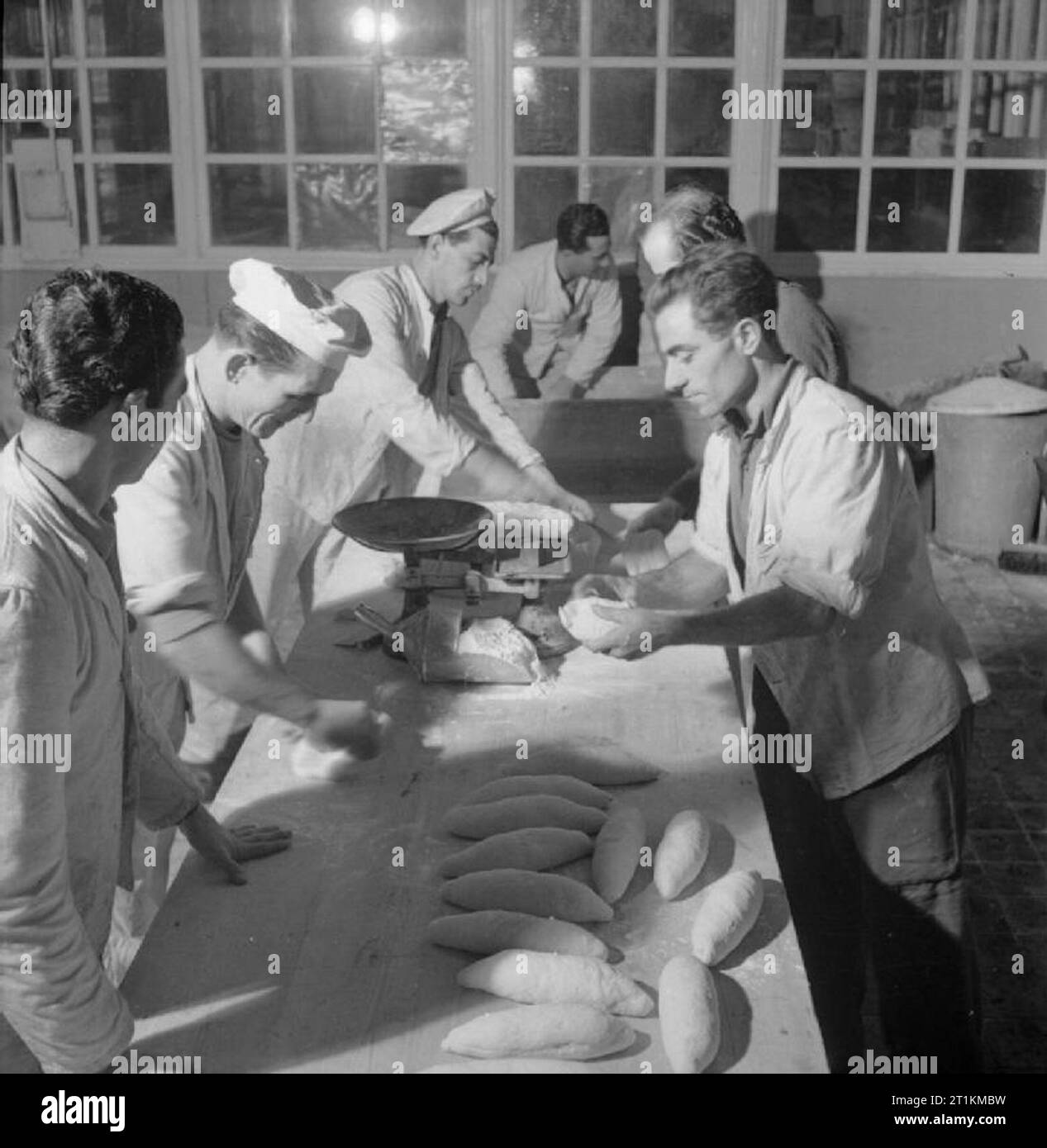 Italian Prisoners of War in Britain- Everyday Life at An Italian Pow Camp, England, UK, 1945 Bakers shape loaves of bread in the bakery of the N.144 Italian workers camp near London. The men are Bacchisio Bellu, Salvatore Mura, Mario Raimondis, Rosario Di Stefano and Antonio Annicchiarico. Stock Photo