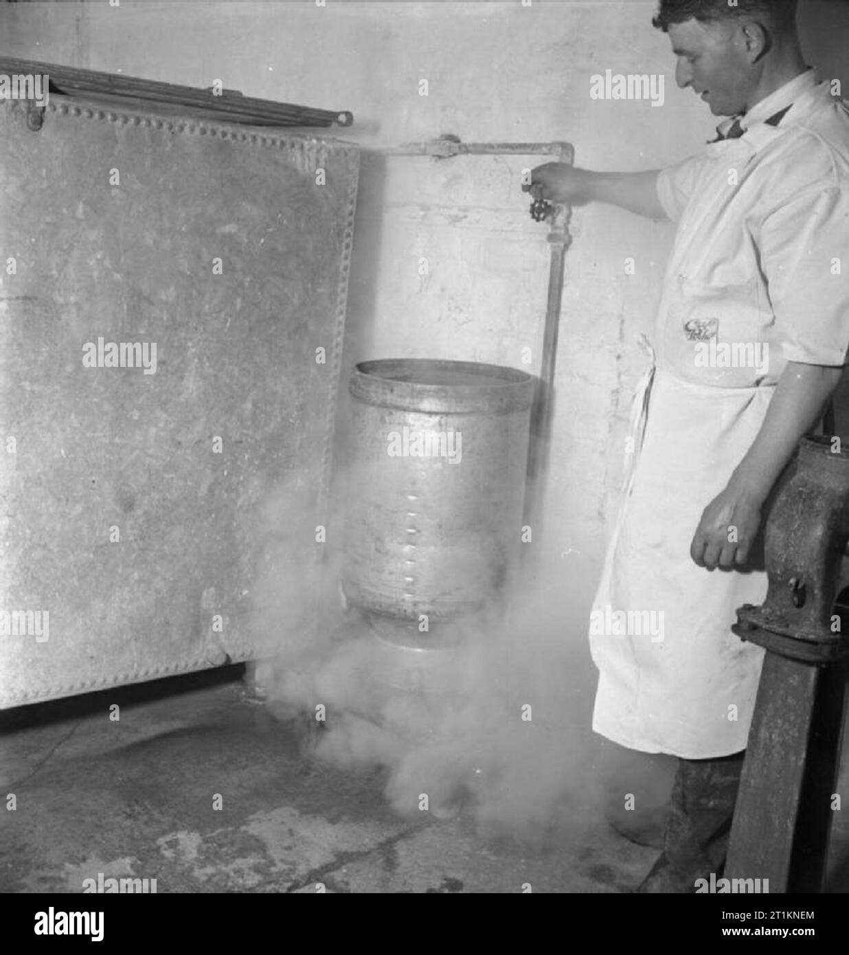 Milk Production- Dairy Farming in Wartime, Norfolk, England, UK, 1944 Milk churns are sterilised by steam at a dairy farm, somewhere in Norfolk. The original caption states that 'unless this precaution is taken milk may be contaminated by placing it in unsterile churns, thus nullifying the good effects of careful and clean methods of production'. Stock Photo