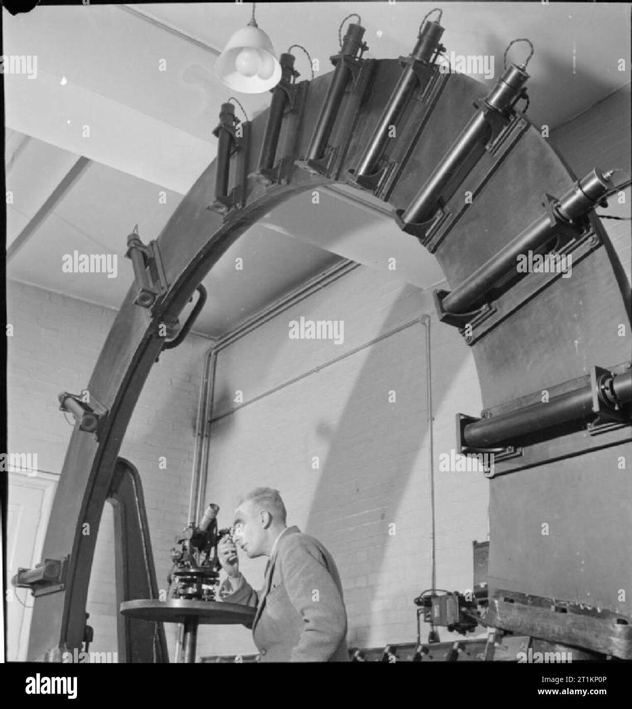 National Physical Laboratory- Science and Technology in Wartime, Teddington, Middlesex, England, UK, 1944 In the Optics Section of the Light Division at the National Physical Laboratory in Teddington, a scientist tests the angular scale of a sextant using a large wheel-like piece of apparatus, which is arranged vertically for economy of space. Stock Photo