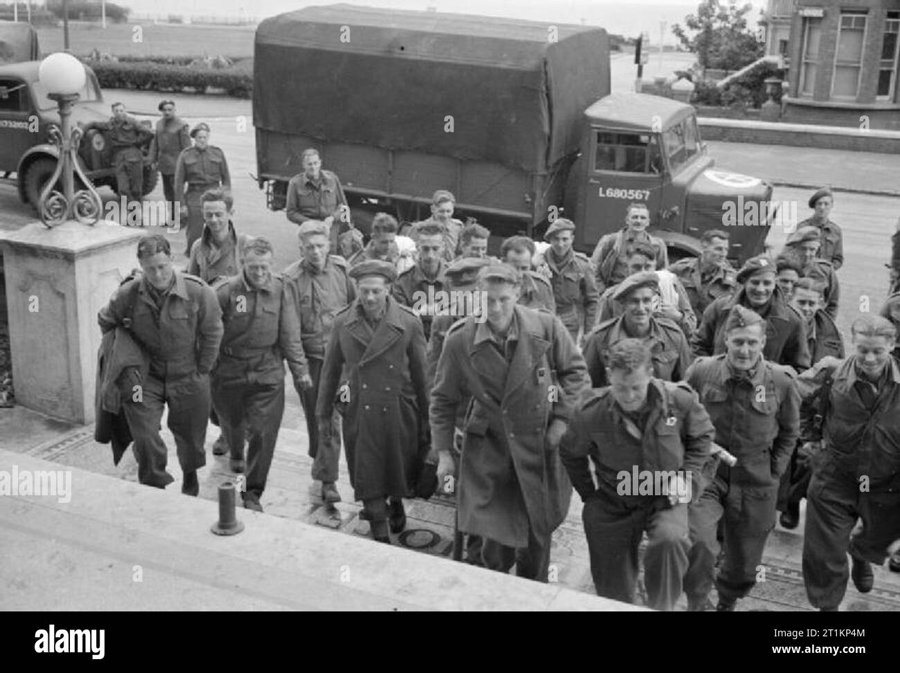 New Zealand Repatriates Arrive in England- Everyday Life For Repatriated Pows in Margate, Kent, England, UK, April 1945 A large group of New Zealand ex-Prisoners of War climb the steps to the grand entrance of the Grand Hotel, Westcliff, Margate, which is being used as a reception centre. Behind them can be seen the trucks which have transported them to the hotel, and the sea is just visible in the background. Stock Photo