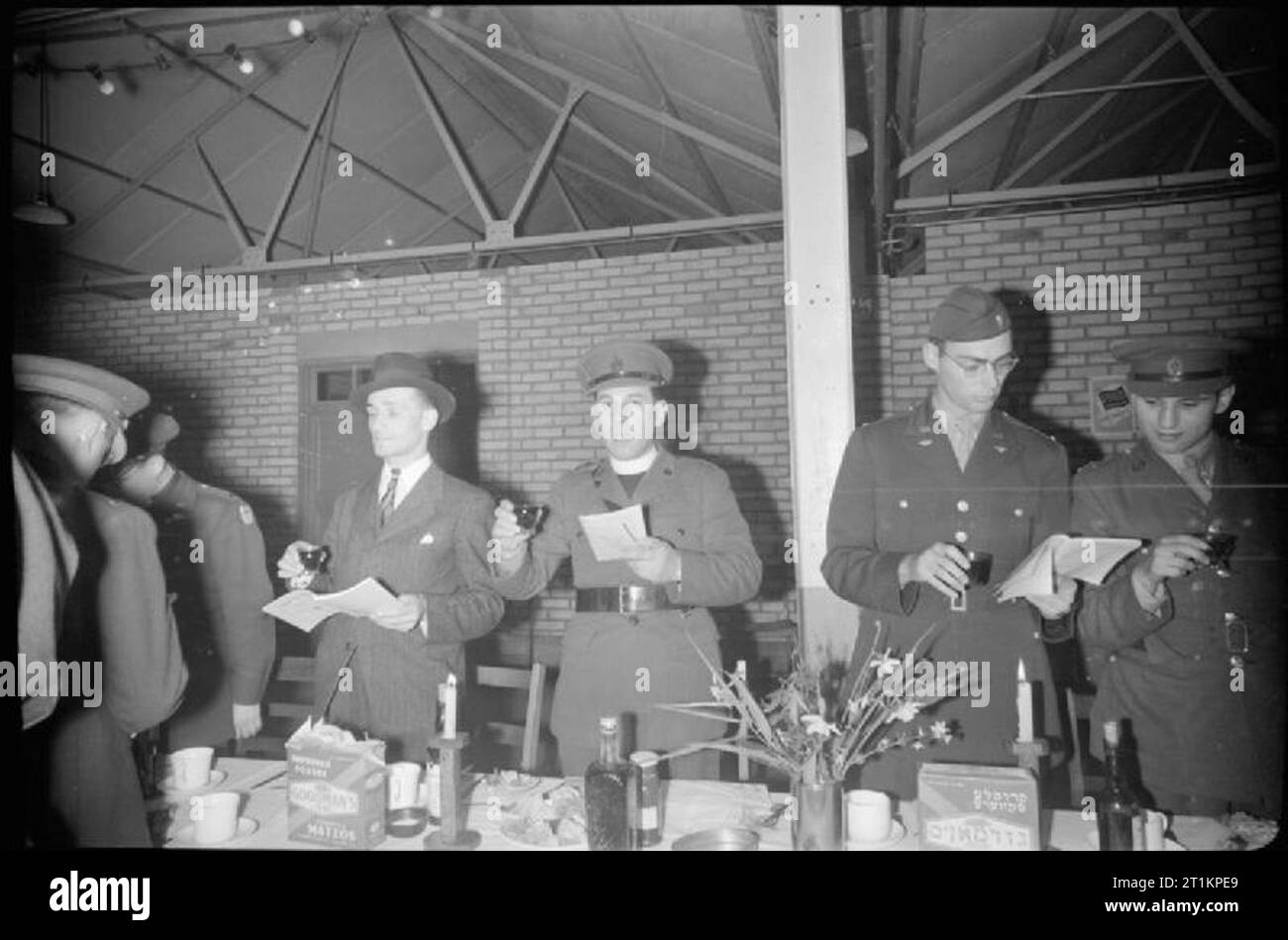 Allied Forces Celebrate Passover- Jewish Traditions in Wartime Britain, April 1944 The Jewish Chaplain to the Forces (centre) raises his glass as he speaks to members of the Allied Forces during their Passover meal in a large hall, somewhere near London. Stock Photo