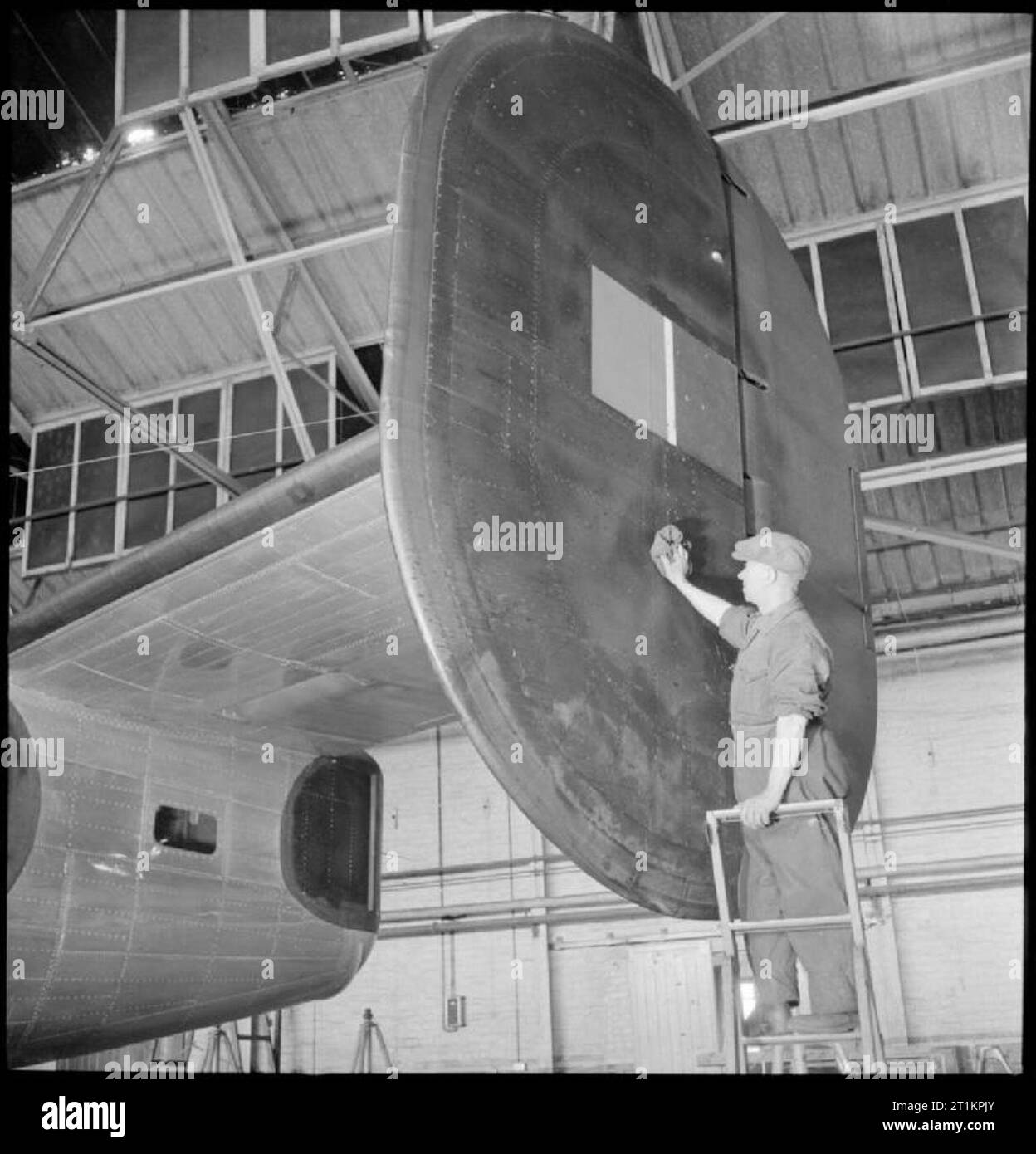 Prestwick Airport- Transport and Travel in Wartime, Prestwick, Ayrshire, Scotland, UK, 1944 A member of the ground crew at Prestwick airport cleans the tail fin of a Consolidated B-24 Liberator aircraft. Stock Photo