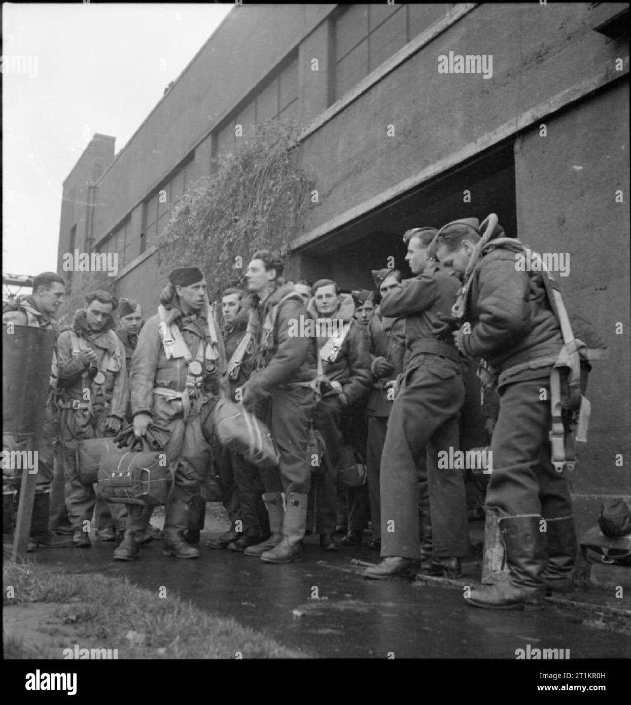 Royal Air Force Bomber Command 1939-1941. Handley Page Halifax crews of No. 35 Squadron RAF await transport to their aircraft outside one of the Type C hangars at Linton-on-Ouse, Yorkshire. Stock Photo