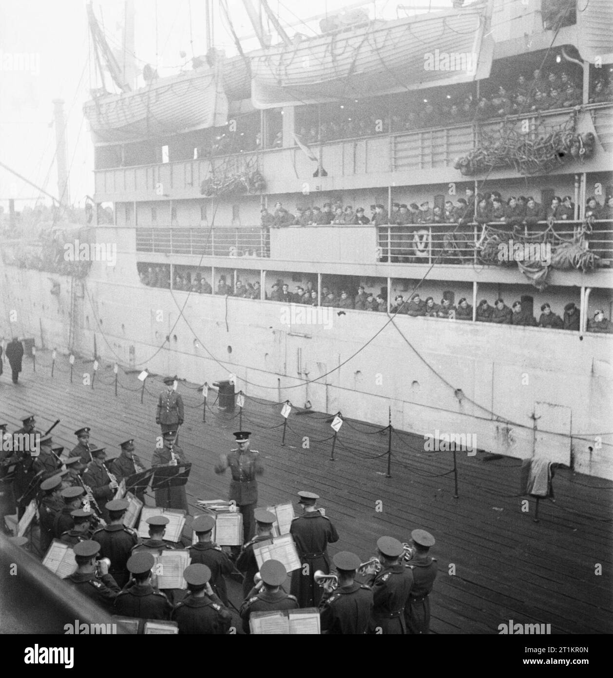 Repatriation of Polish Troops From Britain To Poland, 1945-1948 A scene at Tilbury docks: on the dockside, the Guards band entertains the thousands of Polish troops on board the SS BANFORA, moored alongside, as they wait to depart from England. Many of them would face prosecution at the hands of communist regime for serving alongside the Western Allies. Stock Photo