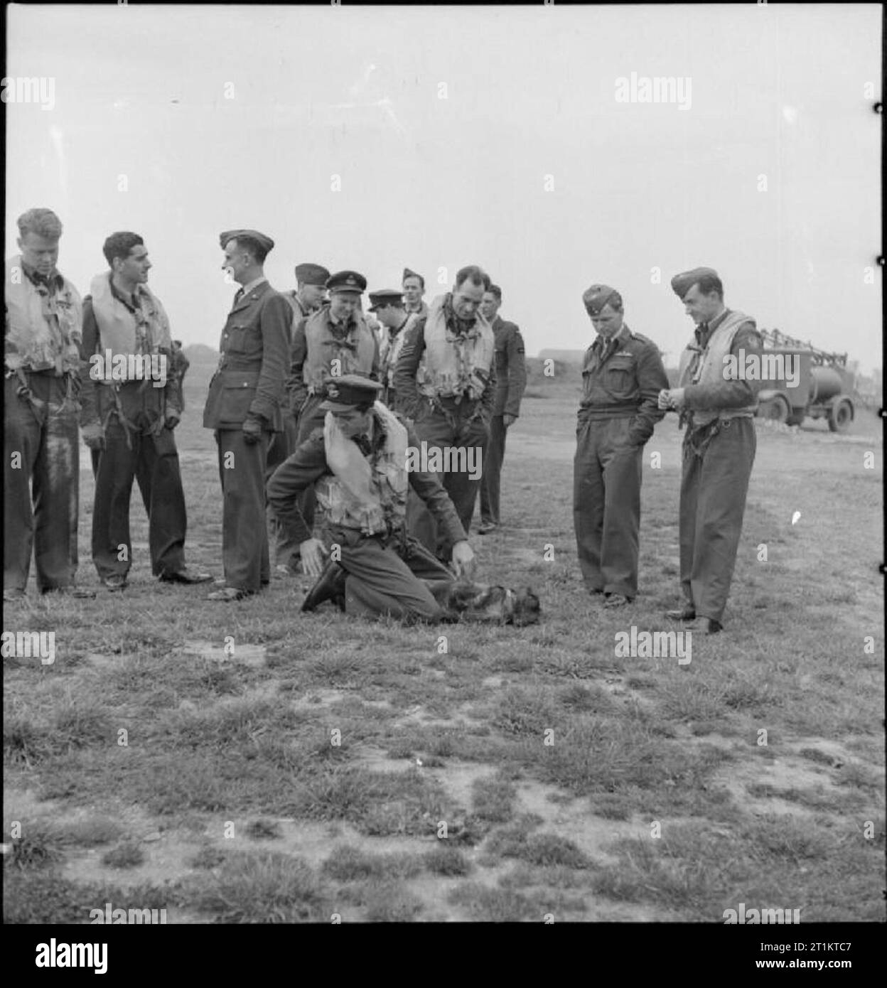 Americans in Britain- the work of No 121 (eagle) Squadron RAF, Rochford, Essex, August 1942 Men of No 121 (Eagle) Squadron stand and wait for their call to action on the grass at Rochford airfield. Left to right they are: Flying Officer K M Osbourne, Squadron Leader W B Williams DFC (the Commanding Officer), an unidentified English officer of the ground staff, Pilot Officer Don A Young, Pilot Officer Frank R Boyles, an unidentified squadron member, Flight Lieutenant Seldon R Edner, Flight Sergeant Jim Sanders, an unidentified squadron member, Pilot Officer Jim Happel and another unidentified s Stock Photo