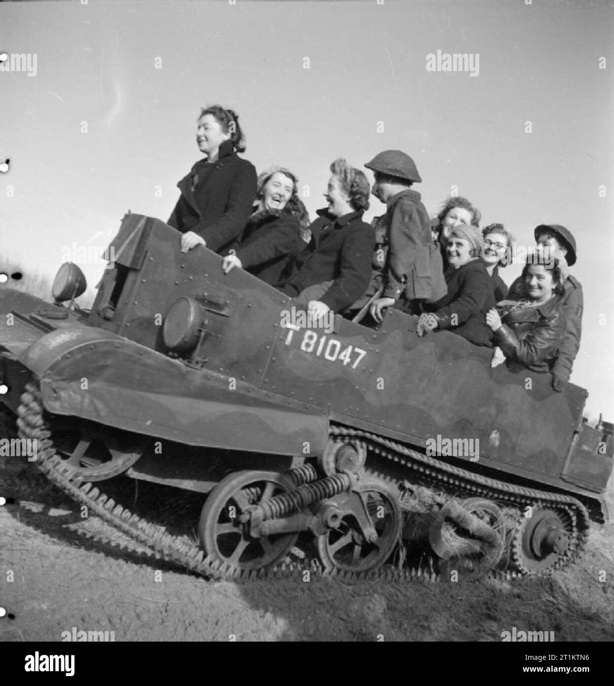 Under Fire - As a Reward- Mortar Bomb Production and Testing at J and F Pool's No 1 Works, Hayle, Cornwall, England, 1943 Women war workers from J & F Pool Ltd, a small West Country arms factory, travel to a test range in a Universal carrier, Mark I. They have been rewarded by the Ministry of Supply for producing 1 million mortar bombs with a trip to see some of their handiwork in action. Stock Photo