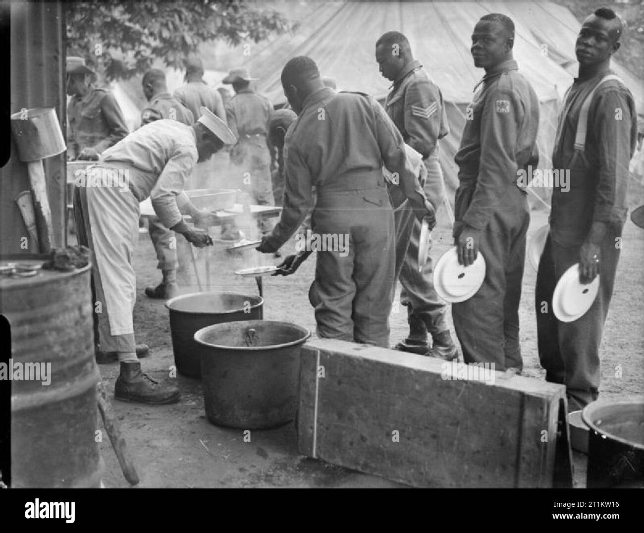 Victory Marchers Camp in London- Accommodation in Kensington Gardens, London, England, UK, 1946 Men of various African regiments queue up for their lunchtime meal at their tented camp in Kensington Gardens, London. Stock Photo