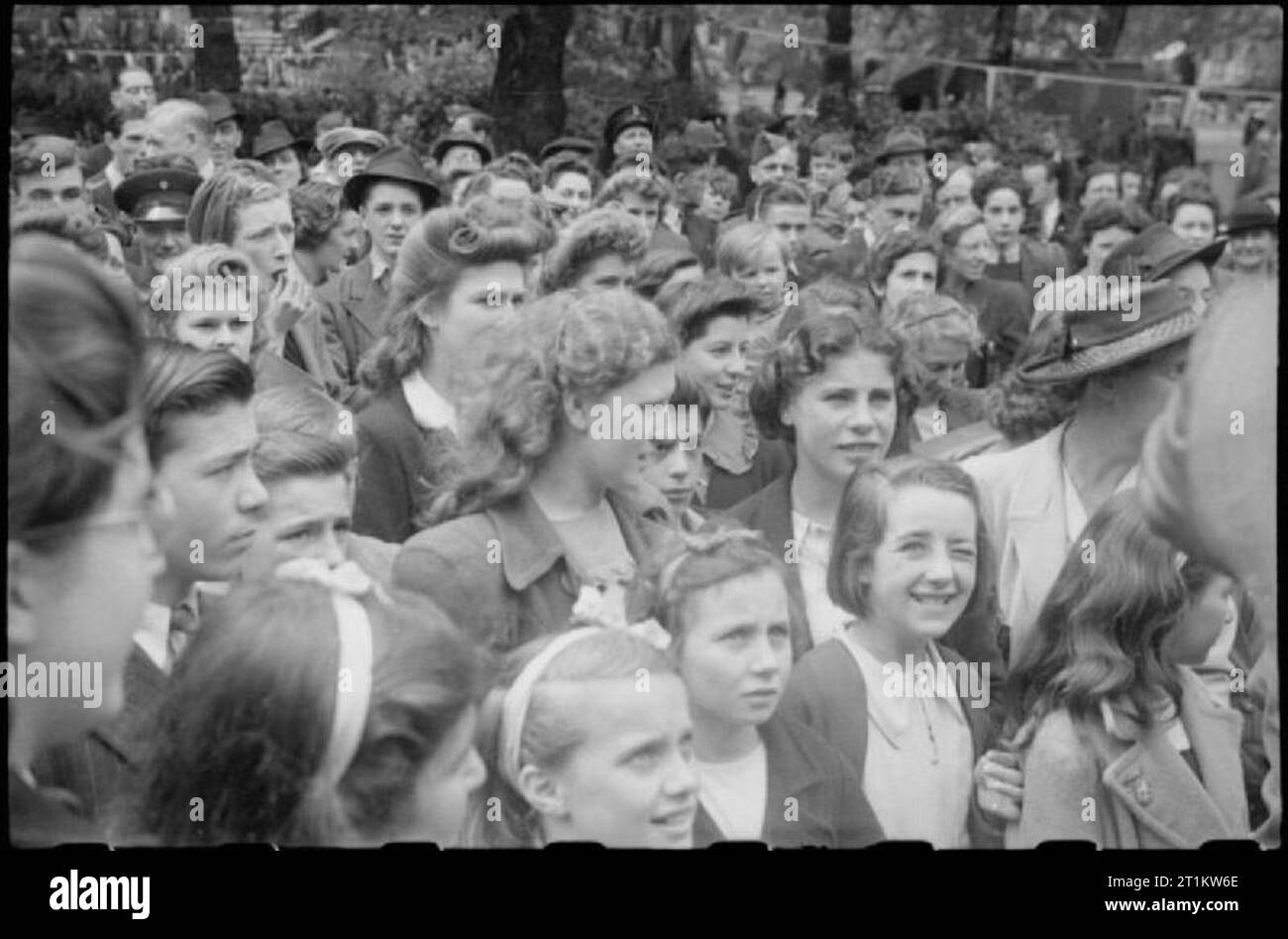 War Fair- Holidays at Home at a Fete in Russell Square, London, 1943 The crowd looks on as film and stage actor Derek de Marnay (not pictured) auctions a very small, very green, banana as part of the festivities in Russell Square. According to the original caption, the piece of fruit fetched ?GBP5. Many of the children pictured here will not have seen a banana before, due to the scarcity of this fruit in wartime. Stock Photo