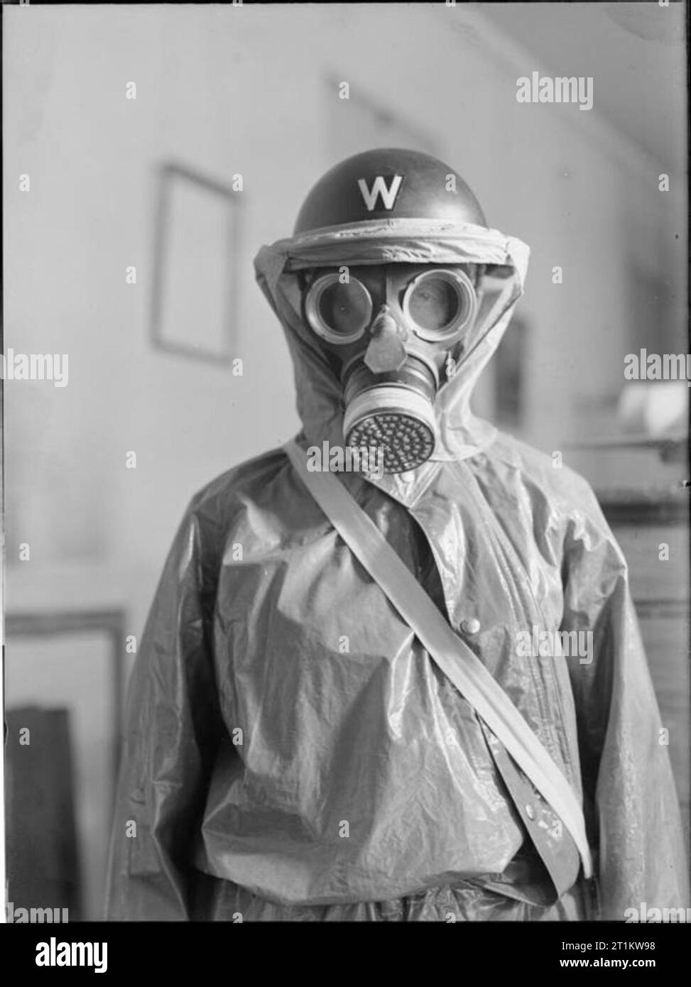 Anti-gas Clothing For Air Raid Wardens, 1941 A half length portrait of an Air Raid Warden wearing gas protective clothing, gas mask and steel helmet. The gas protection outfit is an oilskin overall, similar in style to Churchill's 'siren suit'. Stock Photo