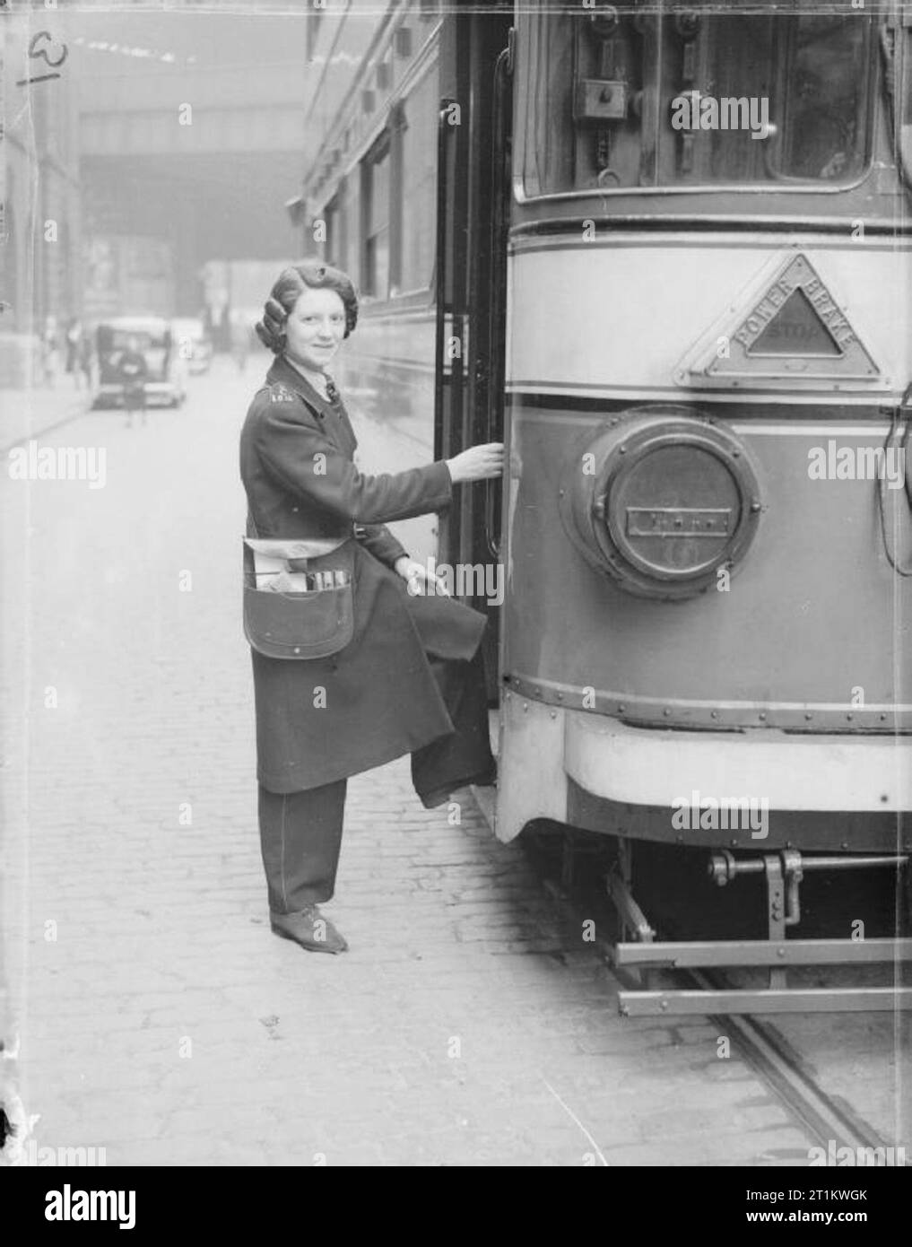Women Transport Workers in Wartime, C 1942 Mrs Winifred Twigg, a tram conductress, climbs aboard her tram in Leeds, England. Stock Photo