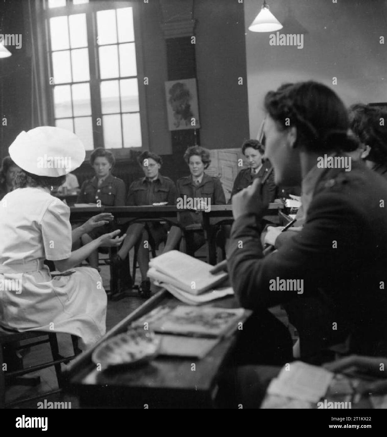 Ats Domestic Science Course in Notting Hill Gate, London, 1944 Chief instructor, Mrs Evans, talks to a class of girls on one of the Domestic Science Courses given to members of the Auxiliary Territorial Service (ATS) by the London District of the Army Education Scheme. The course was run in the Domestic Science block of London County Council's Avondale Park School in Notting Hill Gate. Stock Photo
