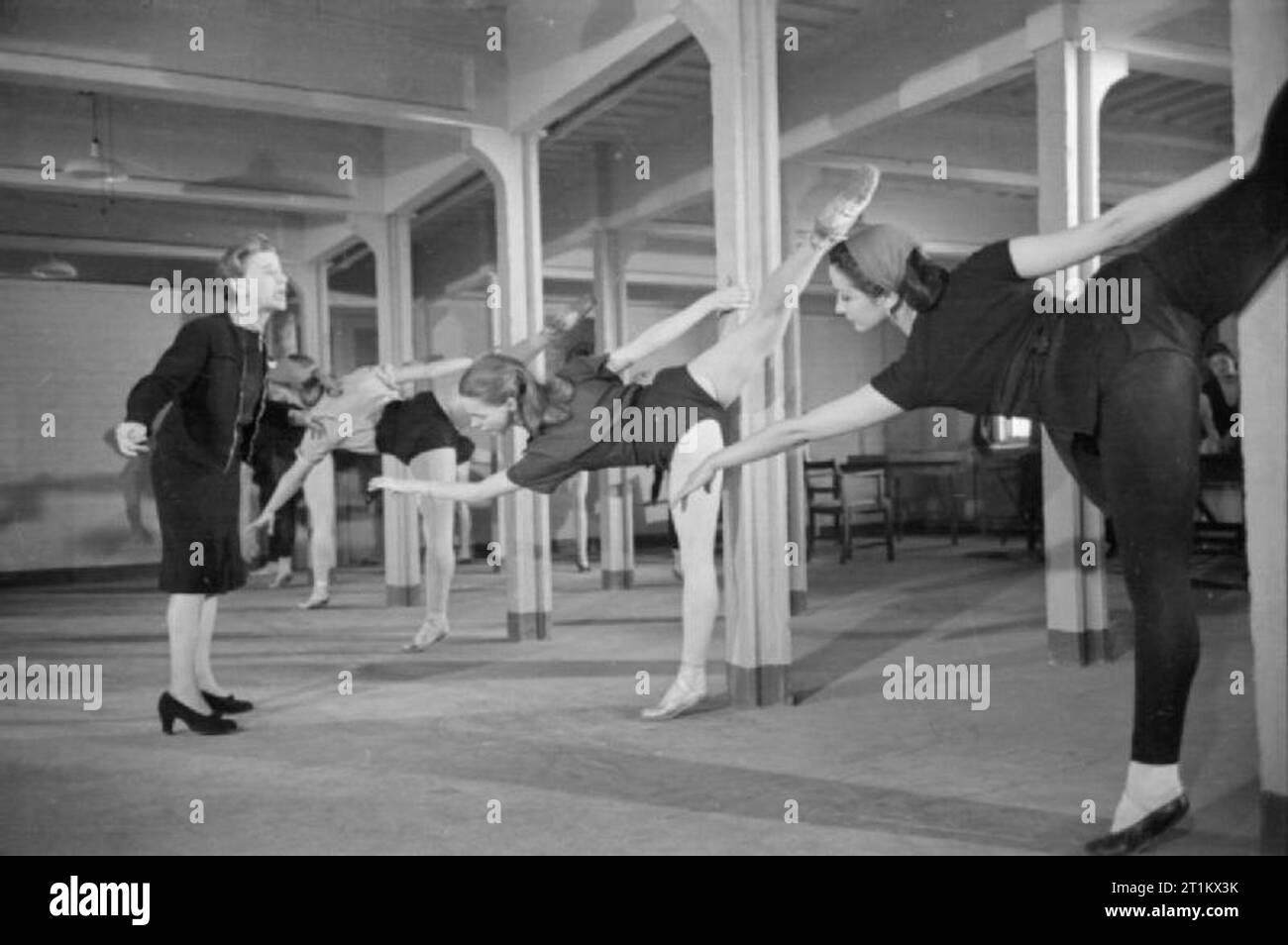 Ballet Goes To the Factory- Dance and Entertainment Organised by the Council For the Encouragement of Music and the Arts, England, 1943 Marie Rambert, founder and director of the Ballet Rambert (left), directs members of her company as they rehearse in the games room of the factory hostel. The rehearsal is taking place in the morning, whilst the factory workers are busy at their jobs. Stock Photo