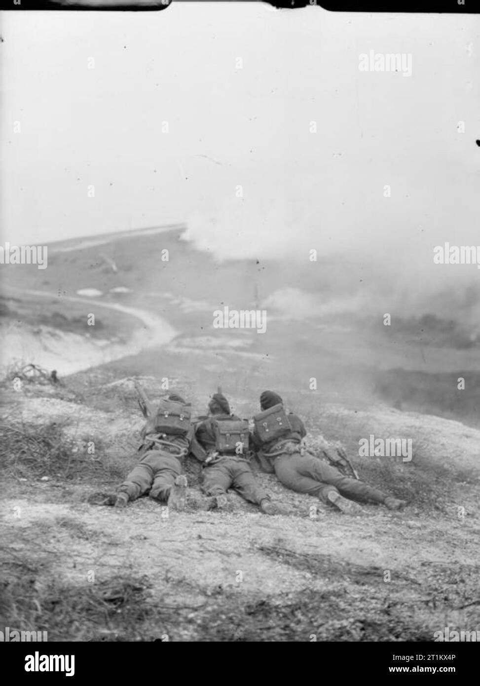 Belgian Commandos in Training in Britain, 1945 Three Belgian Commando trainees lie on the ground during a training exercise somewhere in Britain, waiting for the smoke to provide sufficient cover to launch their assault. Stock Photo