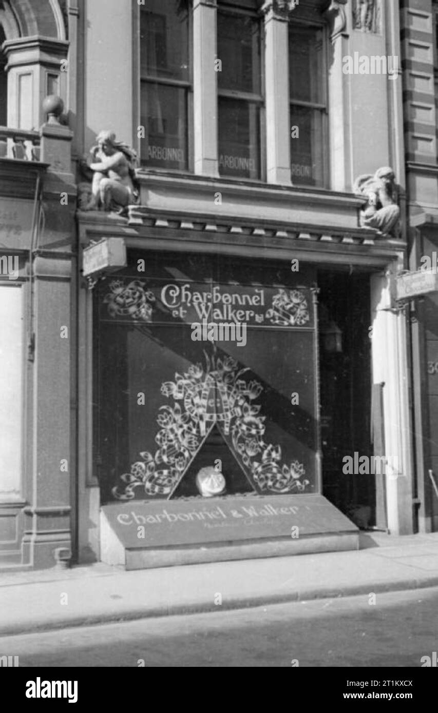 Blackout and Air Raid Precautions in London, England, 1941 A view of the shopfront of chocolatier Charbonnel et Walker, in London's Mayfair, showing that the majority of the shop window has been boarded up, with the exception of a small triangular opening in which to display their goods. The aim of this was to prevent plate glass windows being smashed during air raids. Stock Photo