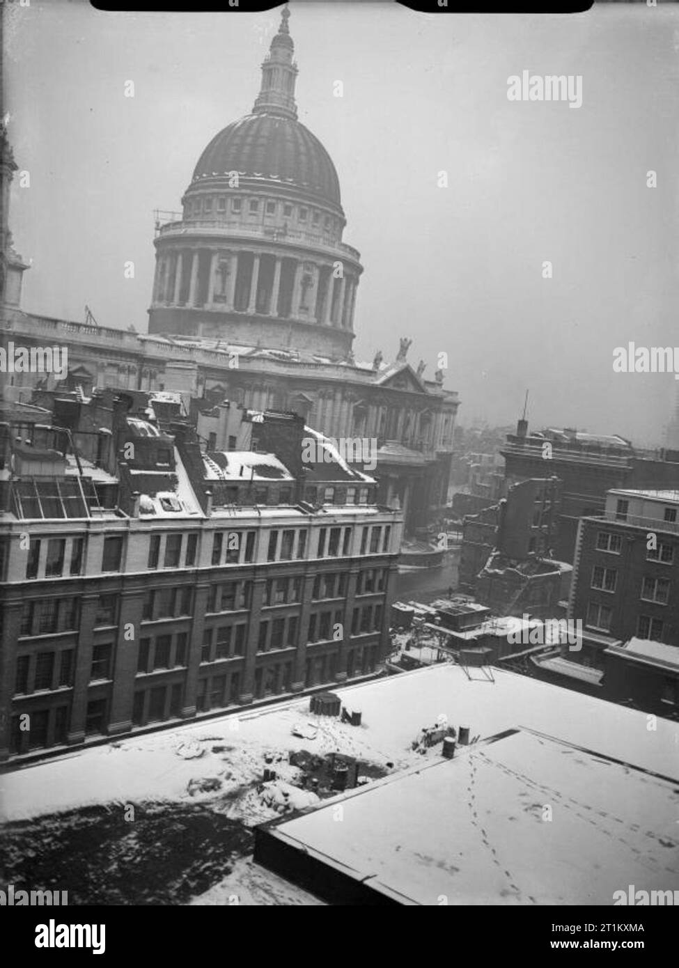 Bomb Damage in London, England, January 1942 A view of St Paul's Cathedral through bomb damage and snow. Stock Photo