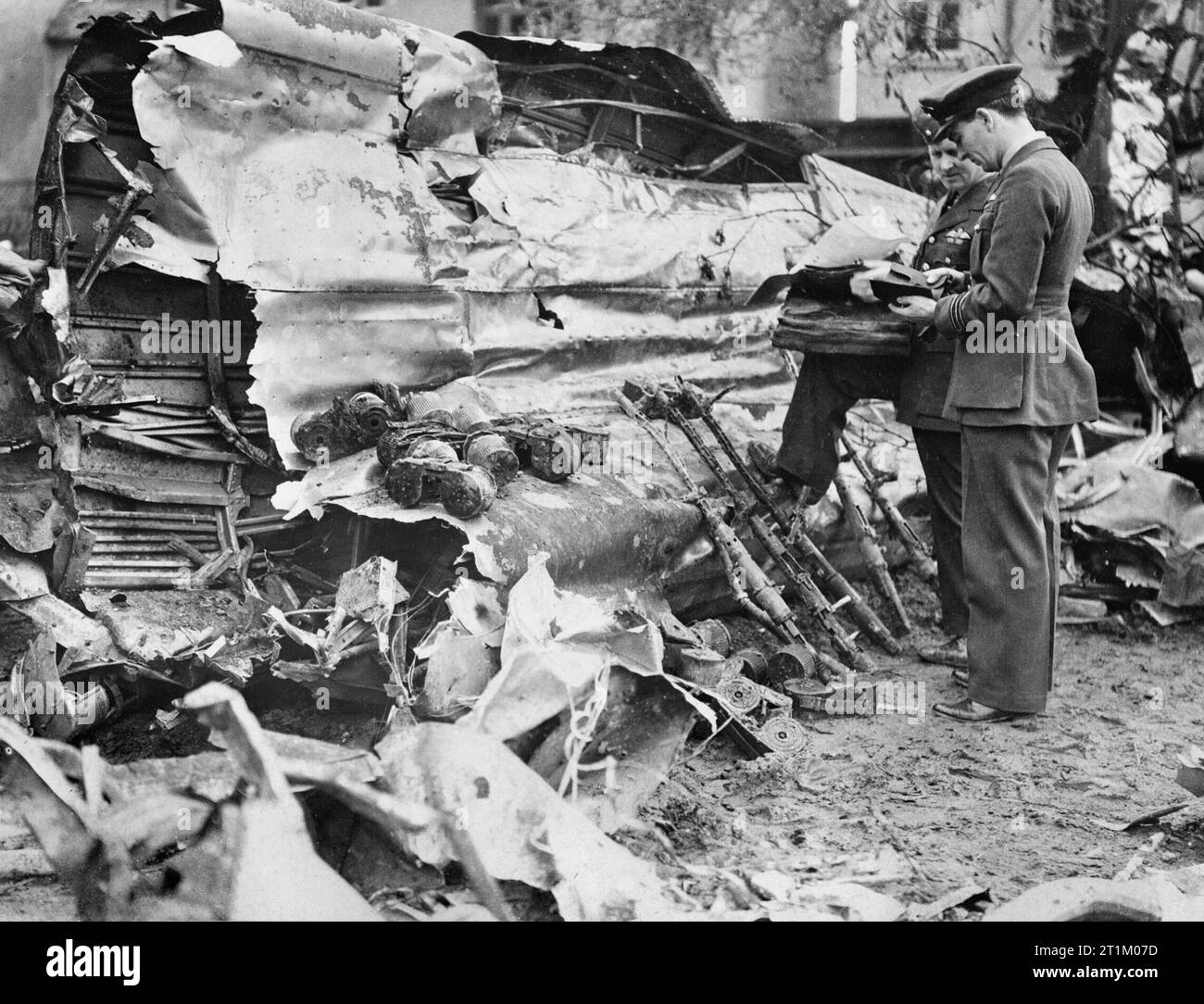 Luftwaffe Raids Over Britain Two senior RAF officers examining the wreckage of a Heinkel He 111 which crashed at Clacton, 1 May 1940. The bomber's defensive 7.92mm MG 17 machine guns and ammunition drums have been collected together. Stock Photo