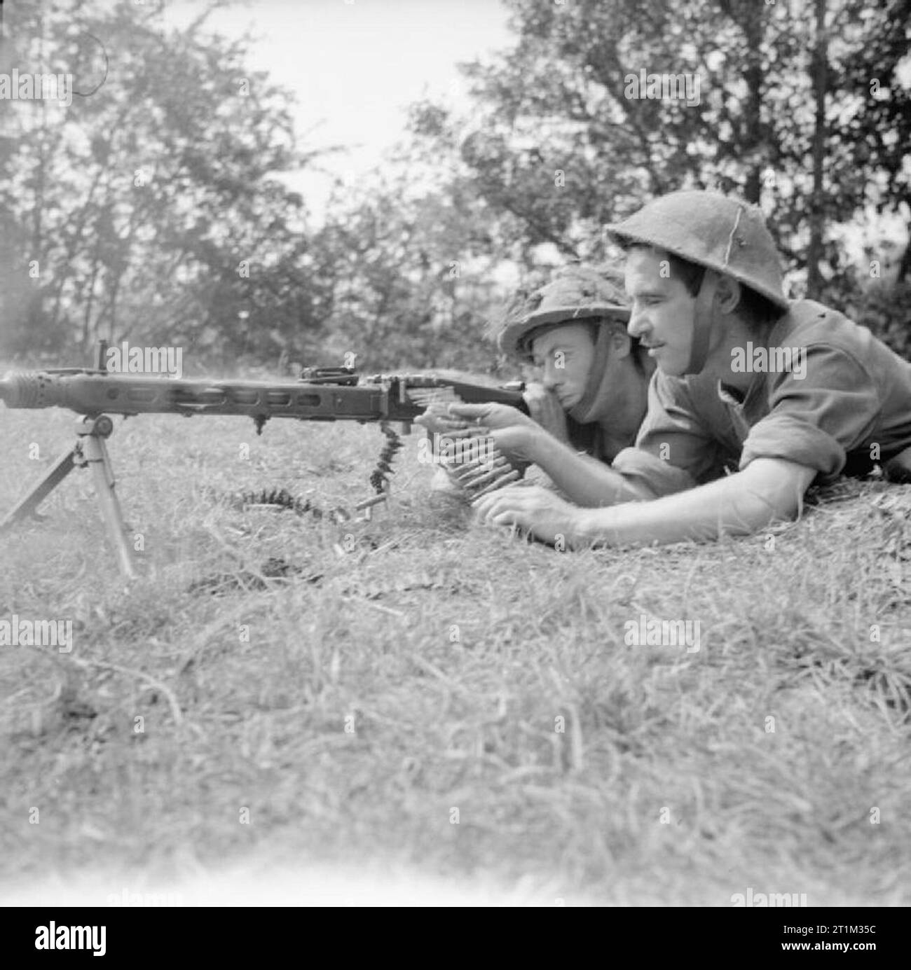 The British Army in Normandy 1944 British troops fire a captured German MG42 machine gun during training at 59th Division's Battle School at Vienne En Bessin, 1 August 1944. Stock Photo