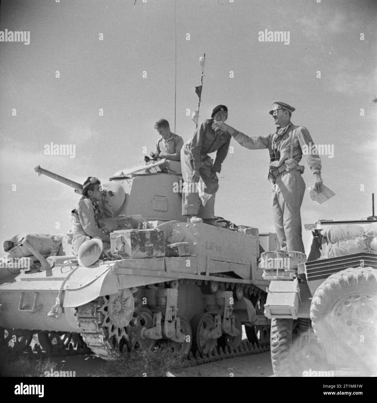 The British Army in North Africa 1942 An officer of the Royal Tank Regiment gives orders from his Daimler scout car to the commander of a Stuart tank in the Western Desert, 18 June 1942. Stock Photo