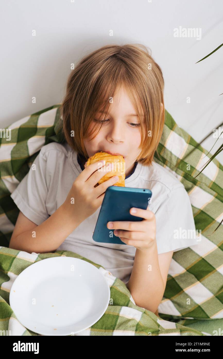 Relaxing In Bed A 9 10 year old Boy With Flowing Hair Indulges In A 30-fun-sleepover-ideas-for-kids-tweens-or-teens-at-a-slumber-party