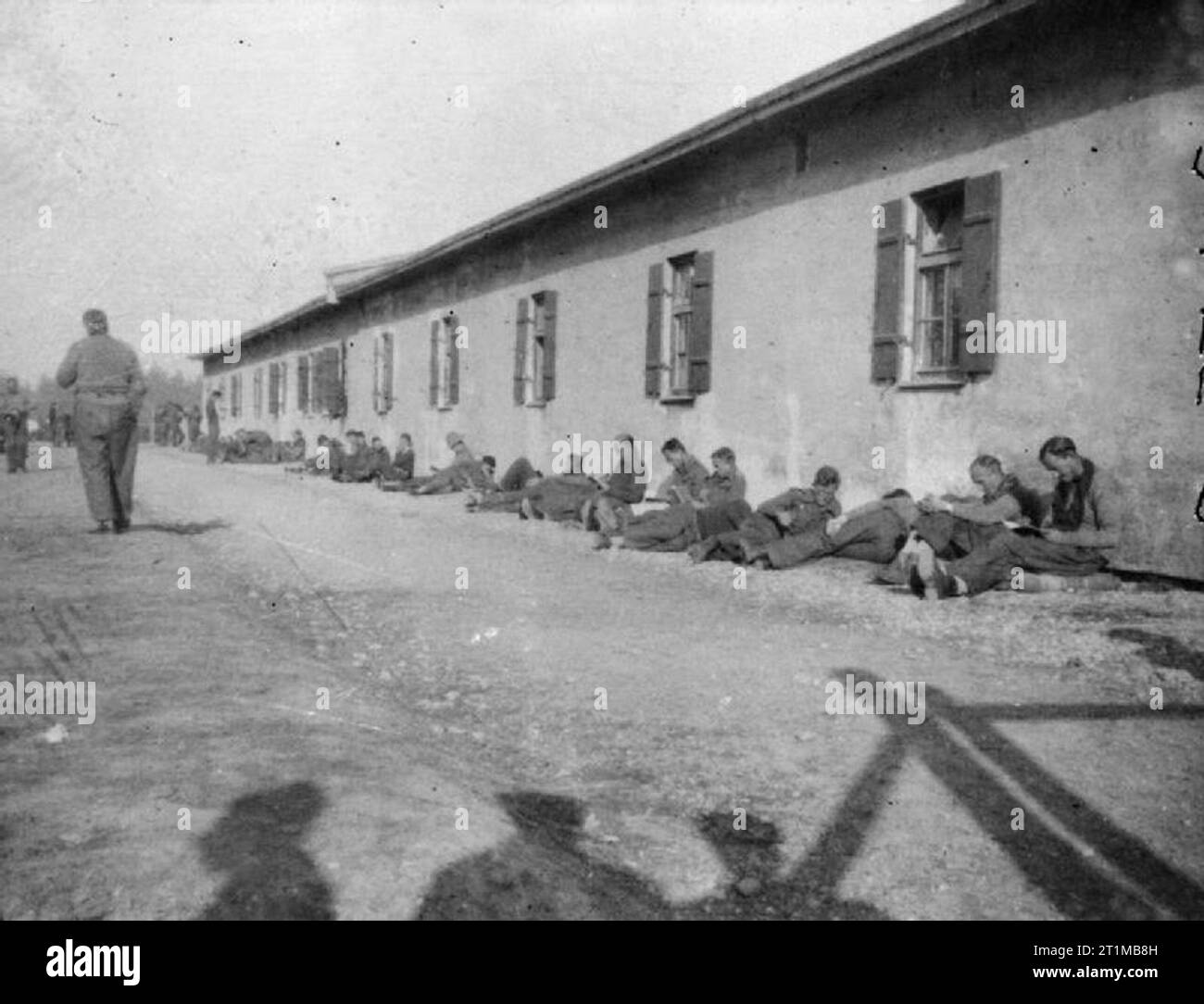 The British Army in North-west Europe 1944-45 A photograph taken covertly at Stalag VIIA at Mooseburg in November 1943, showing British POWs resting by the side of a hut. Stock Photo