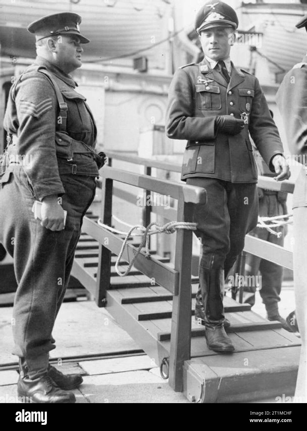 The British Army in the United Kingdom 1939-45 A Luftwaffe officer prisoner is escorted down the gangplank of a hospital ship to exercise on the quayside at Newhaven, 5 October 1941. He was one of a number of German POWs awaiting repatriation in a prisoner exchange. Stock Photo