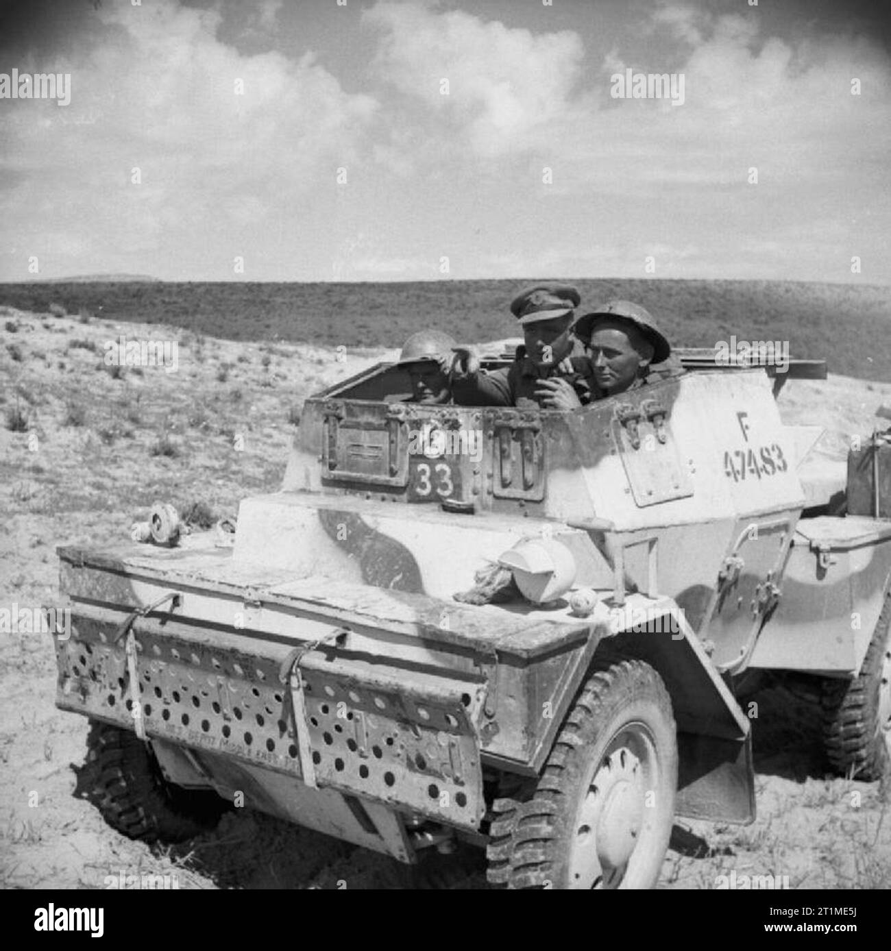 The British Army in Tunisia 1943 Royal Engineers in a Daimler scout car on their way to blow up an abandoned enemy tank, to prevent it being recovered and repaired, 14 March 1943. Stock Photo