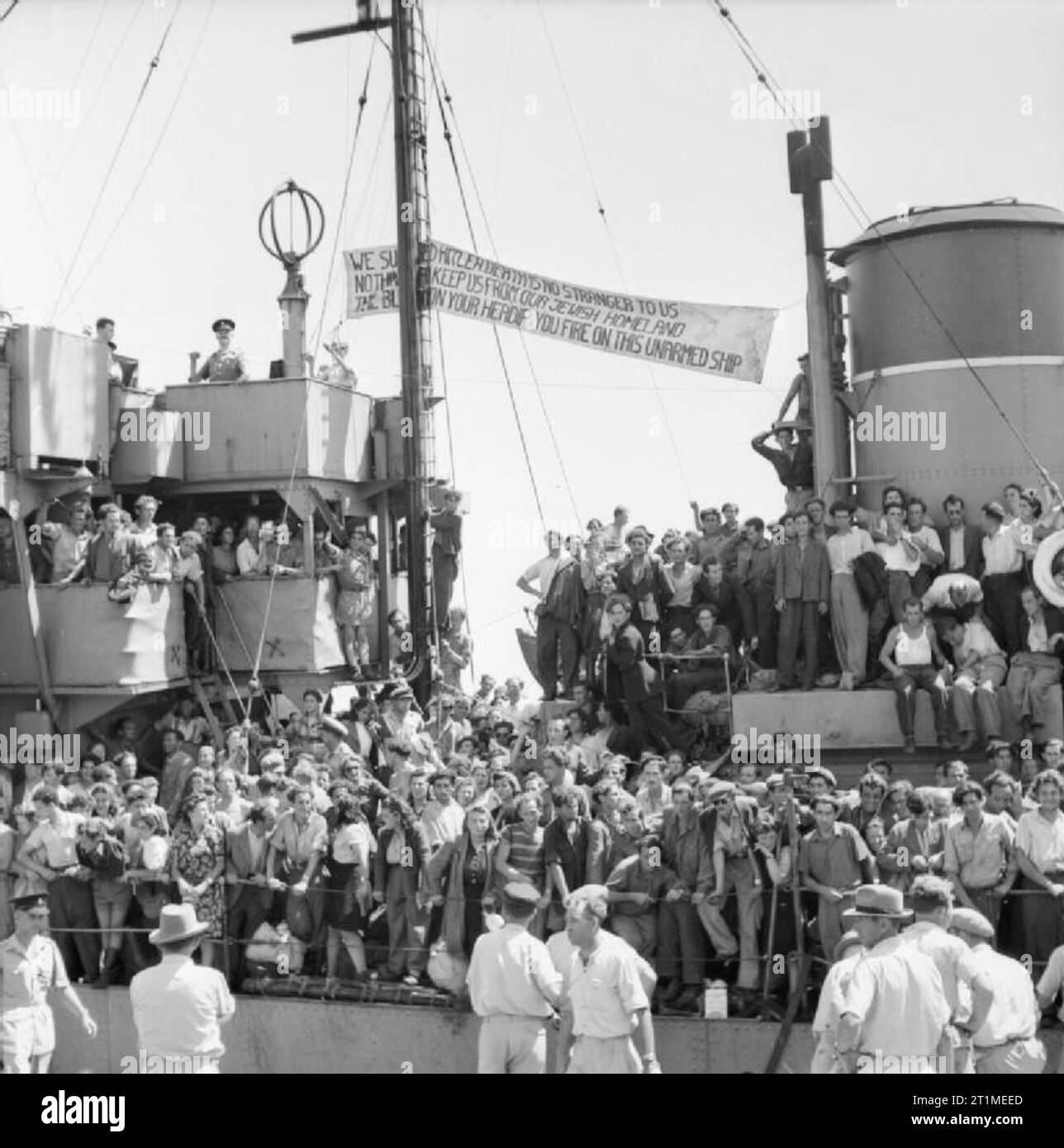 The British Mandate in Palestine 1917-1948 Illegal immigrants arriving into Palestine: Jewish refugees stand tightly packed on board the JOSIAH WEDGWOOD on arrival in Haifa harbour. From the funnel to the masts is tied a banner declaring 'We survived Hitler - Death is no stranger to us - Nothing can keep us from our Jewish homeland - The blame is on your head if you fire on this unarmed ship'. Stock Photo