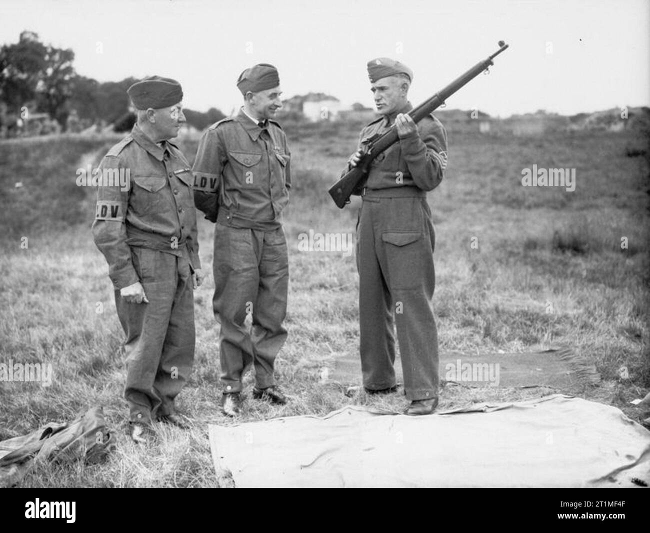 The Home Guard 1939-1945 Local Defence Volunteers: A sergeant instructor explaining the working of a rifle to two members of the Local Defence Volunteers at Bisley range. Stock Photo