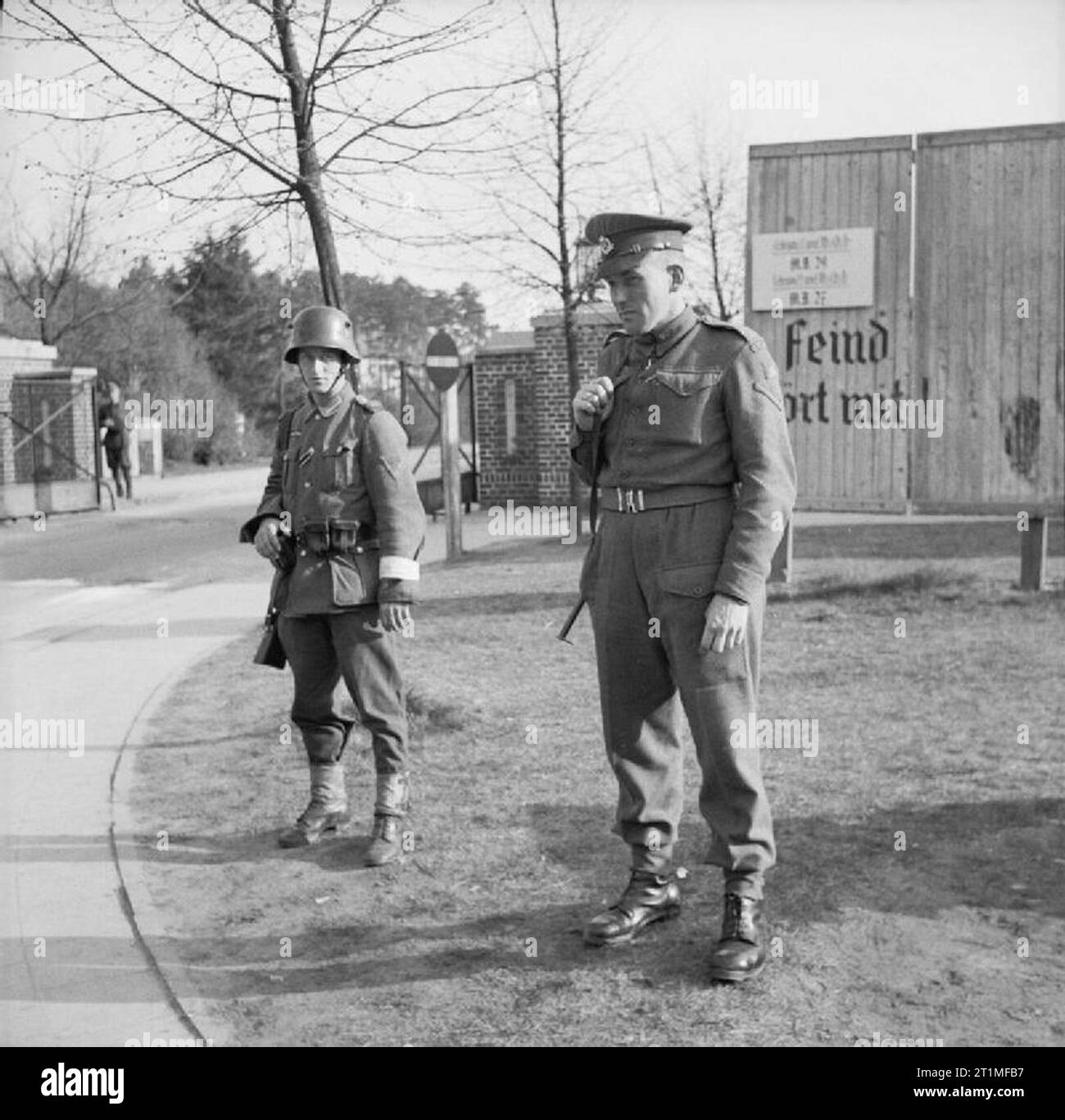 The Liberation of Bergen-belsen Concentration Camp, April 1945 A British military policeman and a Hungarian soldier on guard duty outside the camp. The Hungarian battalion had to remain in the camp under the terms of the truce and the troops were used for labouring duties. Stock Photo