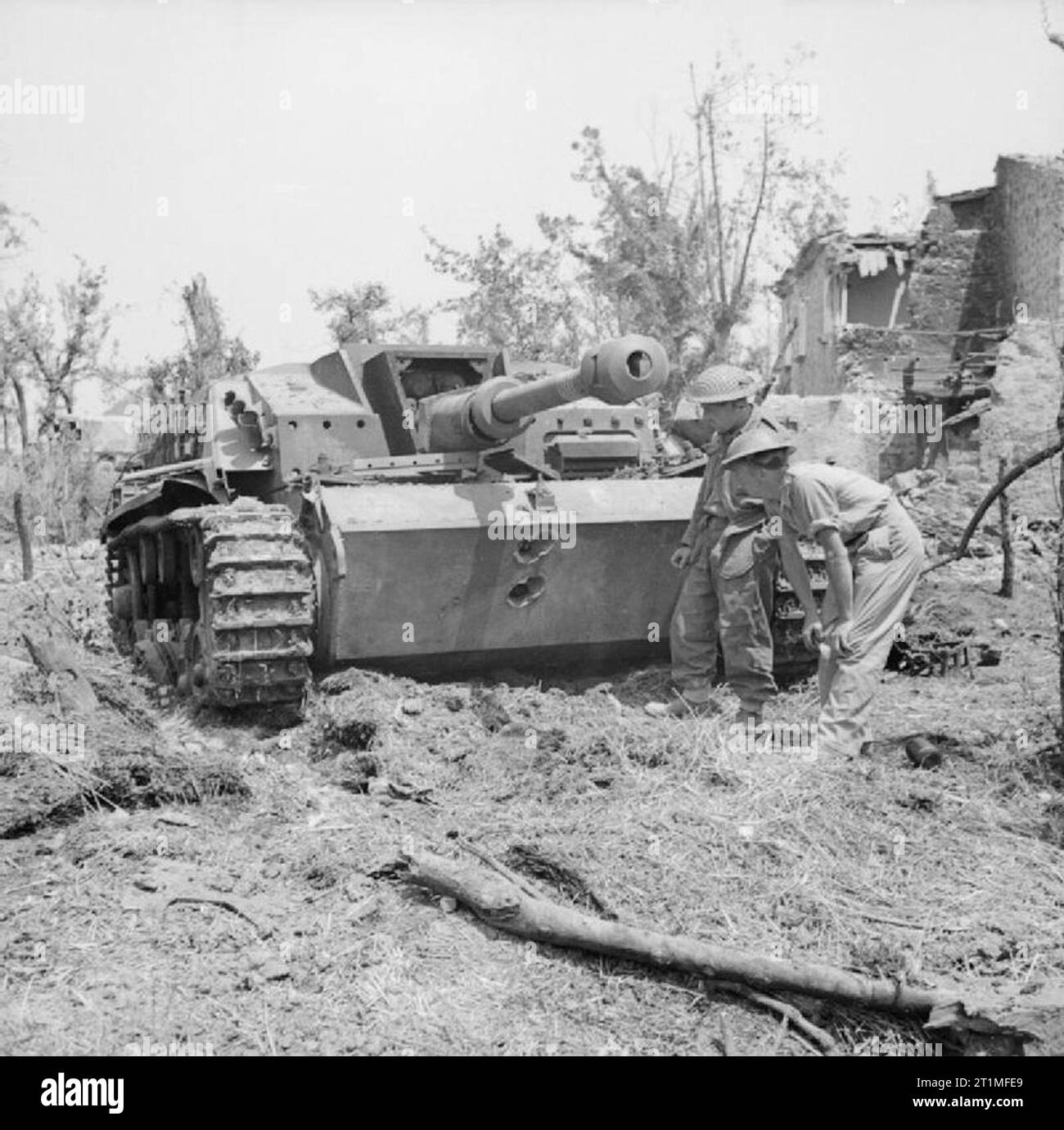 British troops examine a knocked-out German StuG III assault gun near Cassino, Italy, 18 May 1944. Troops examine a knocked-out German StuG III assault gun near Cassino, 18 May 1944. Two 75mm AP rounds from a Sherman tank have neatly penetrated its front armour. Stock Photo