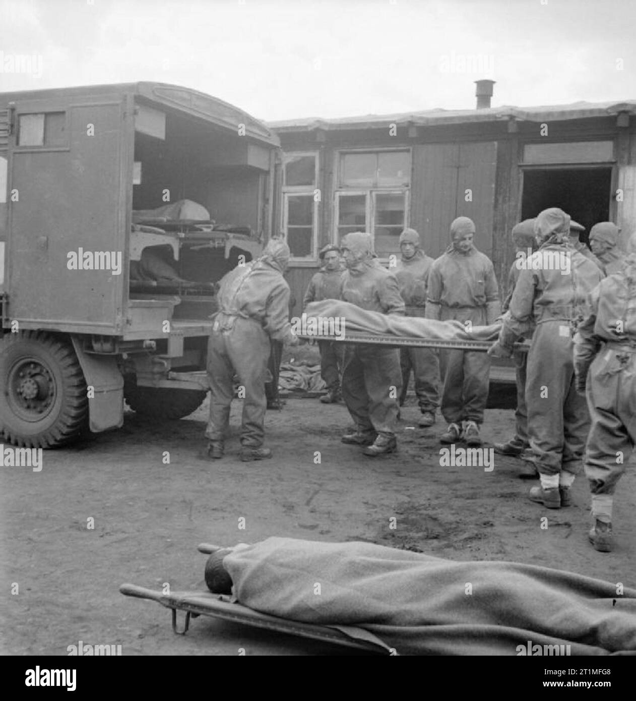The Liberation of Bergen-belsen Concentration Camp, May 1945 Men of 11 Light Field Ambulance, Royal Army Medical Corps, wearing protective clothing, evacuate an inmate suffering from typhus from Camp No 1. By 2 May 1945, 6,500 of the sick had been evacuated to hospital. Stock Photo