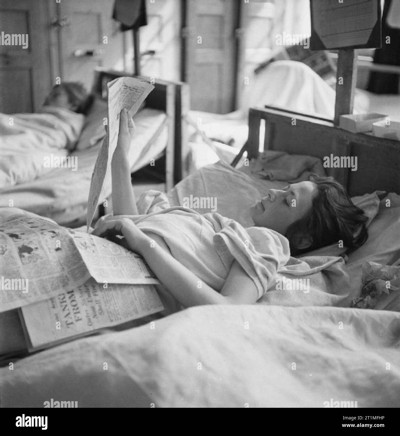 The Liberation of Bergen-belsen Concentration Camp, May 1945 For the first time in four years, a young Czech girl and former camp inmate is able to read a newspaper while recovering in the hospital set up in Hohne Military Barracks nearby. Stock Photo