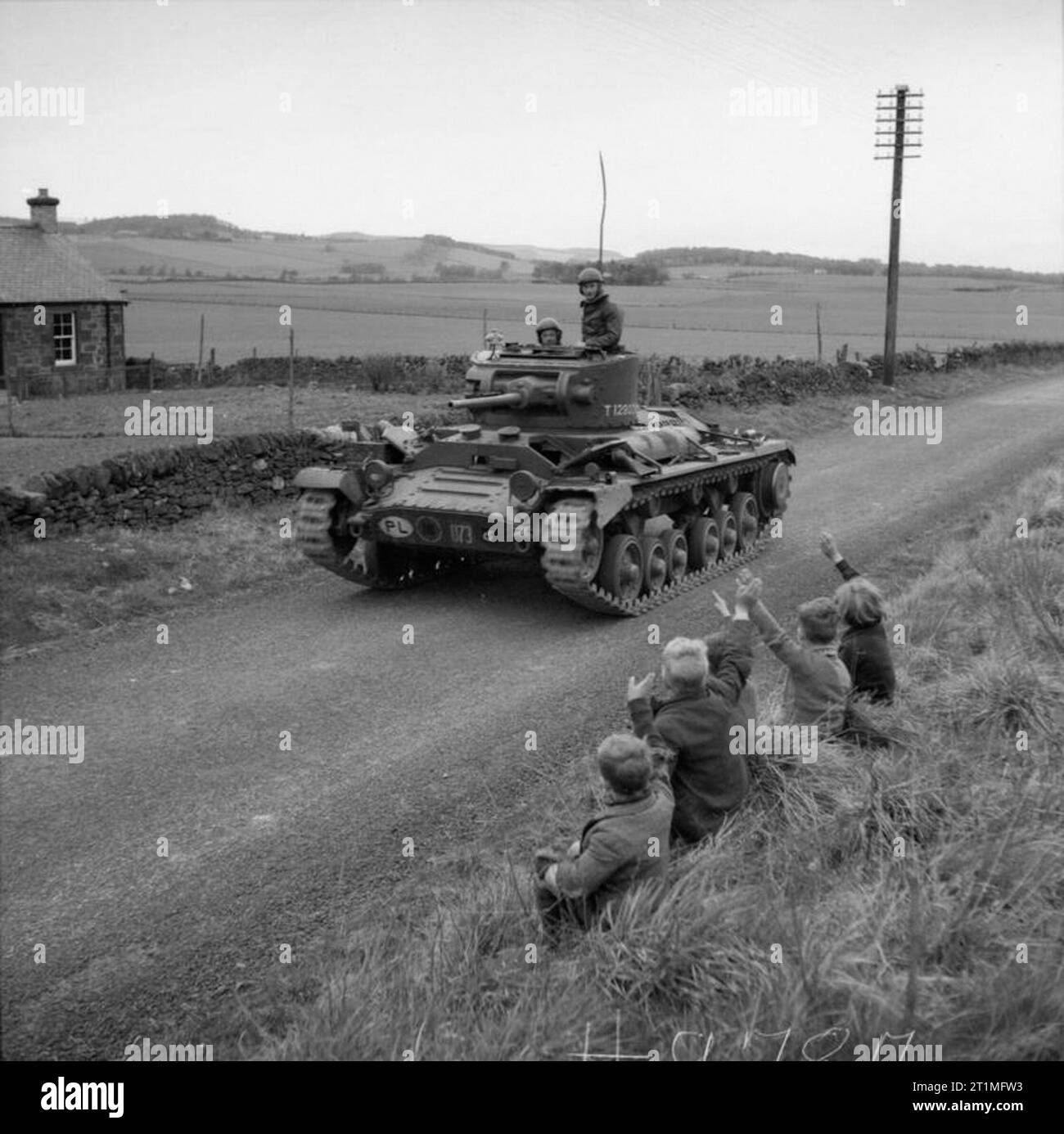 The Polish Army in the United Kingdom, 1940-47 Children waving at Valentine tanks of the 1st Tank Regiment (1st Polish Corps) on the move against the 'invaders' during a mock invasion exercise in Perthshire. Polish troops played the role of the defenders, while Scottish troops (probably the 51st Highland Division) took the part of the invaders. Español: El Ejército Polaco en el Reino Unido, 1940-47 Niños saludando a unos tanques Valentine del 1er Regimiento de Tanques (1er Cuerpo Polaco) que se desplazan contra los 'invasores' durante un ejercicio de defensa contra invasiones en Perthshire, Es Stock Photo