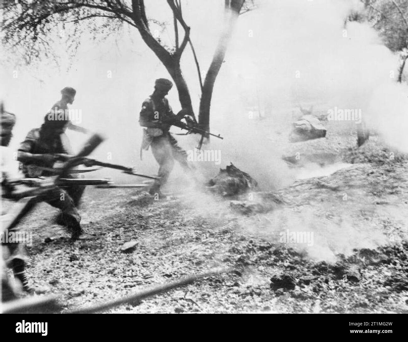 The War in the Far East- the Burma Campaign 1941-1945 The Campaign in Mandalay February - March 1945: Men of a Sikh regiment clear a Japanese foxhole at Mandalay with machine gun fire after throwing in a phosphorus grenade. Stock Photo