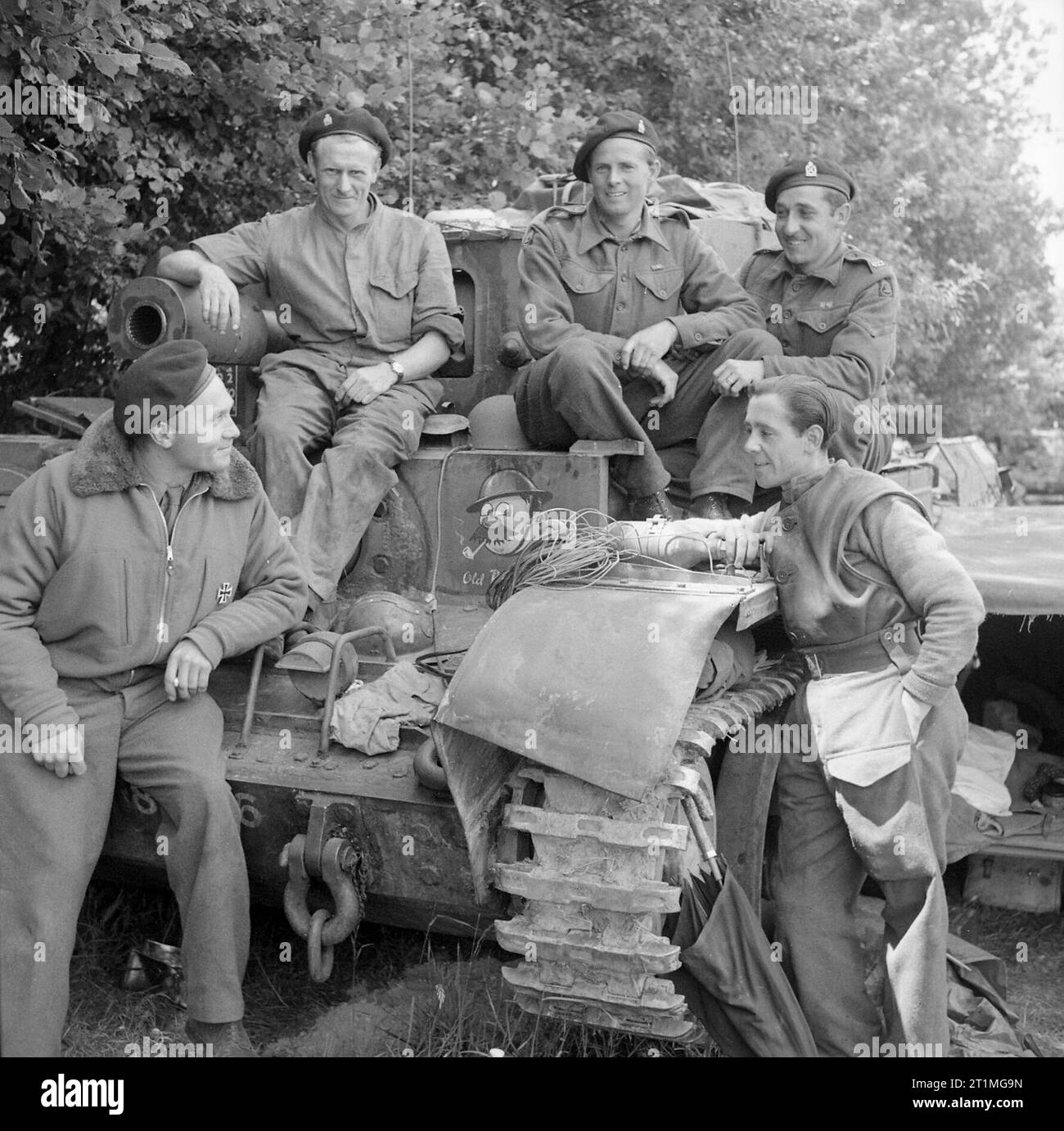 Captain L Cotton MM with his Cromwell Mk VI tank and crew of 4th County of London Yeomanry, 7th Armoured Division, Normandy, 17 June 1944. Captain L Cotton MM (left, wearing a 'liberated' German Iron Cross!) with his Cromwell VI tank, 'Old Bill', and crew of 4th County of London Yeomanry, 7th Armoured Division, 17 June 1944. Cotton had been promoted to captain following the regiment's action at Villers Bocage. Stock Photo