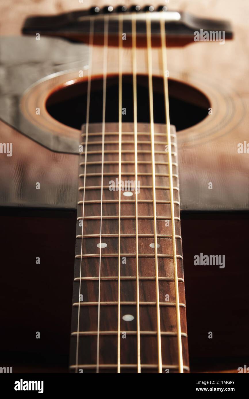 Dark detailed macro view of acoustic guitar frets and string and soundboard. Musical instruments