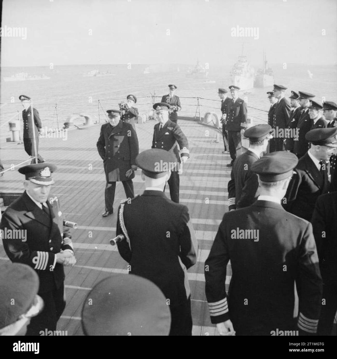 Winston Churchill Visiting the Home Fleet during the Second World War The Prime Minister, Mr Winston Churchill, aboard one of the Royal Navy warships that had just returned from Russia after escorting a convoy. With him is Rear Admiral R Burnett, who commanded the escorting ships. Note the Royal Navy cameraman immediately behind the Prime Minister. Stock Photo