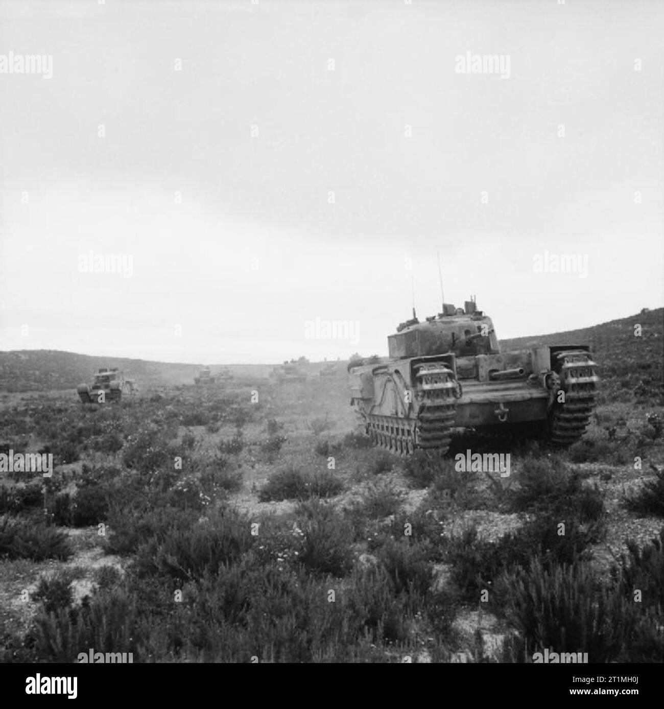 Churchill tanks advance in Tunisia, 24 April 1943. Churchill tanks advance, 24 April 1943. In the lead is a Mk I with hull-mounted 3-inch howitzer. Stock Photo