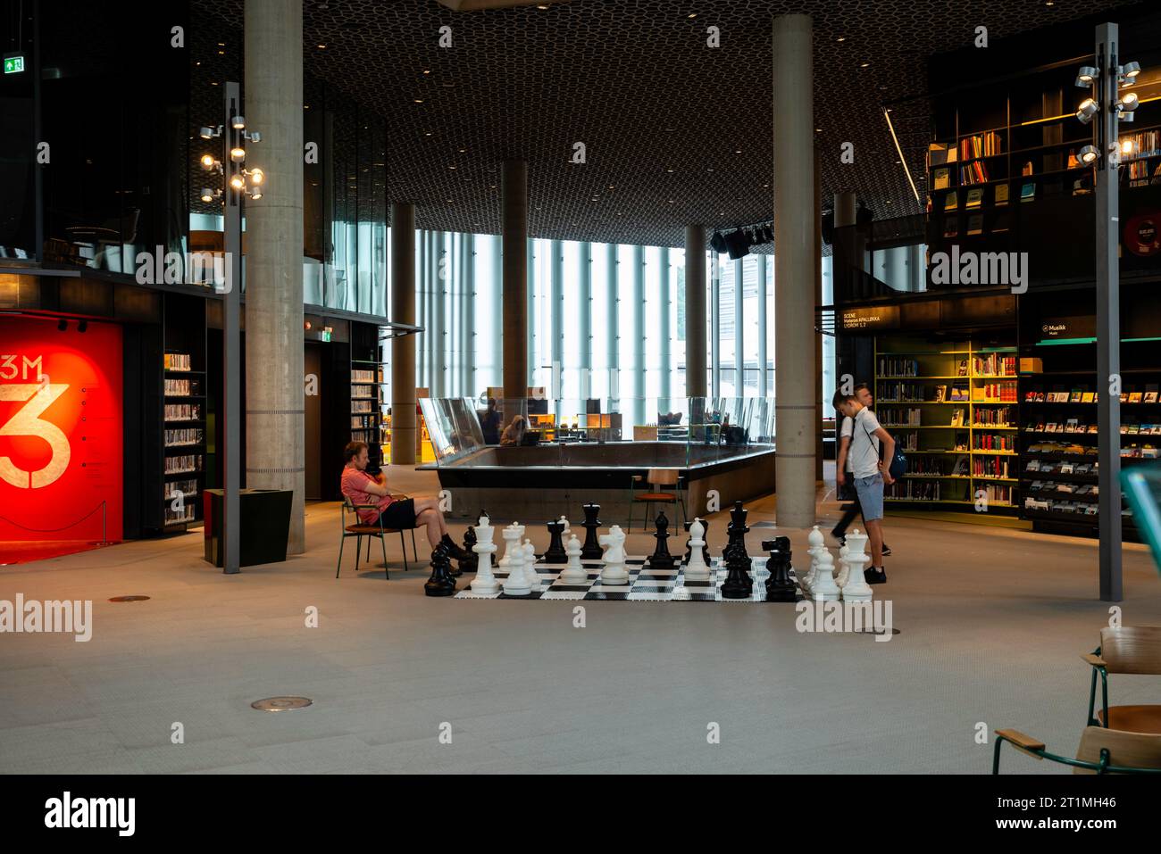 A father and son play on an large chessboard; Deichman Bjørvika/Oslo Public Library, Oslo, Norway. Stock Photo