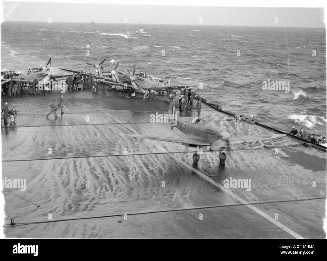 Royal Air Force- Malta and the Mediterranean, 1940-1943. Operation PICKET I: Supermarine Spitfire Mark VB(T), BP844, the first of a further nine Spitfires to reinforce the RAF on Malta, taking off from the flight deck of HMS EAGLE with Squadron Leader E J 'Jumbo' Gracie at the controls. Behind him, the other aircraft await their turn. These Spitfires, equipped with 90-gallon ferry drop tanks, flew to Ta Kali to re-equip No. 126 Squadron RAF, which Gracie was to command. BP844 was shot down over Malta, with the loss of its pilot, on 2 April 1942. Stock Photo