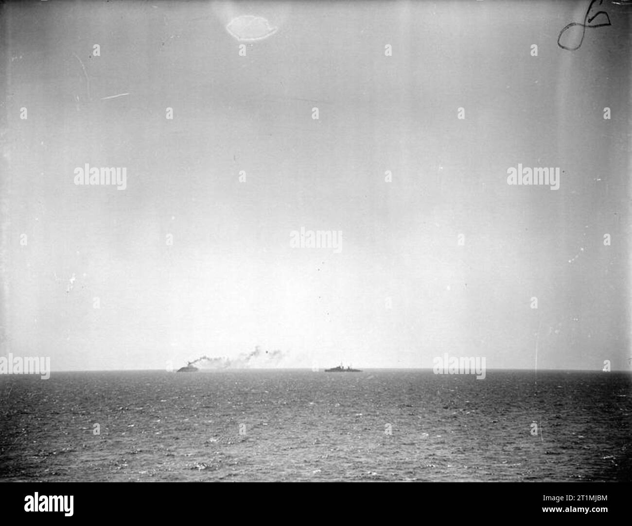 The End of the British Aircraft Carrier, HMS Eagle, Whilst on Convoy Duty To Malta. 19 August 1942. Ships of the escort force near the EAGLE as she lists heavily to port. Stock Photo