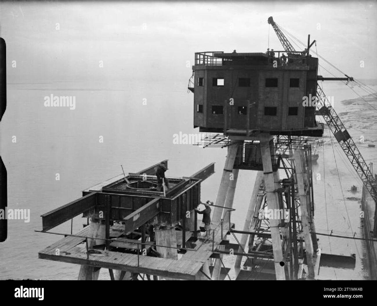 The Royal Navy during the Second World War 120 foot Maunsell anti-aircraft forts for use in the Mersey Estuary under construction at Bromborough Dock. Here the partially completed accommodation block has been fitted to the four long legs that will rest on the sea bed. Stock Photo