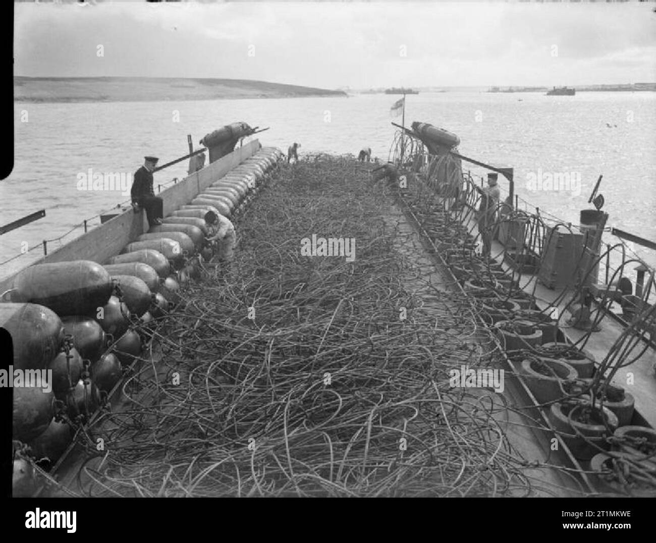 The Royal Navy during the Second World War At Scapa Flow, a net laying vessel. This specially adapted vessel lays anti-submarine or anti-torpedo net whilst underway. The net in this picture, with weights and floats attached, is 900 feet long, weighs over 40 tons and can be laid in 4 minutes. Stock Photo