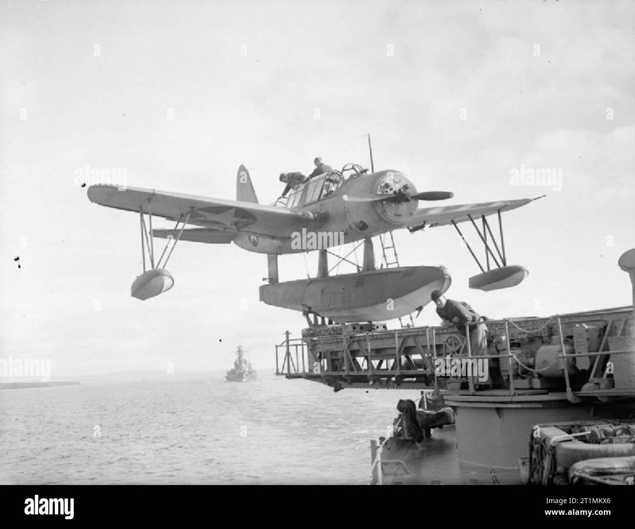 The Royal Navy during the Second World War The observer entering the Vought-Sikorsky Kingfisher aircraft on board USS SOUTH DAKOTA before a flight at Scapa Flow whilst the ship is operating with elements of the Home Fleet. The Kingfisher can operate from their ship while underway and be retrieved by the ship's crane without stopping the ship. The aircraft is mounted on a catapult. Stock Photo
