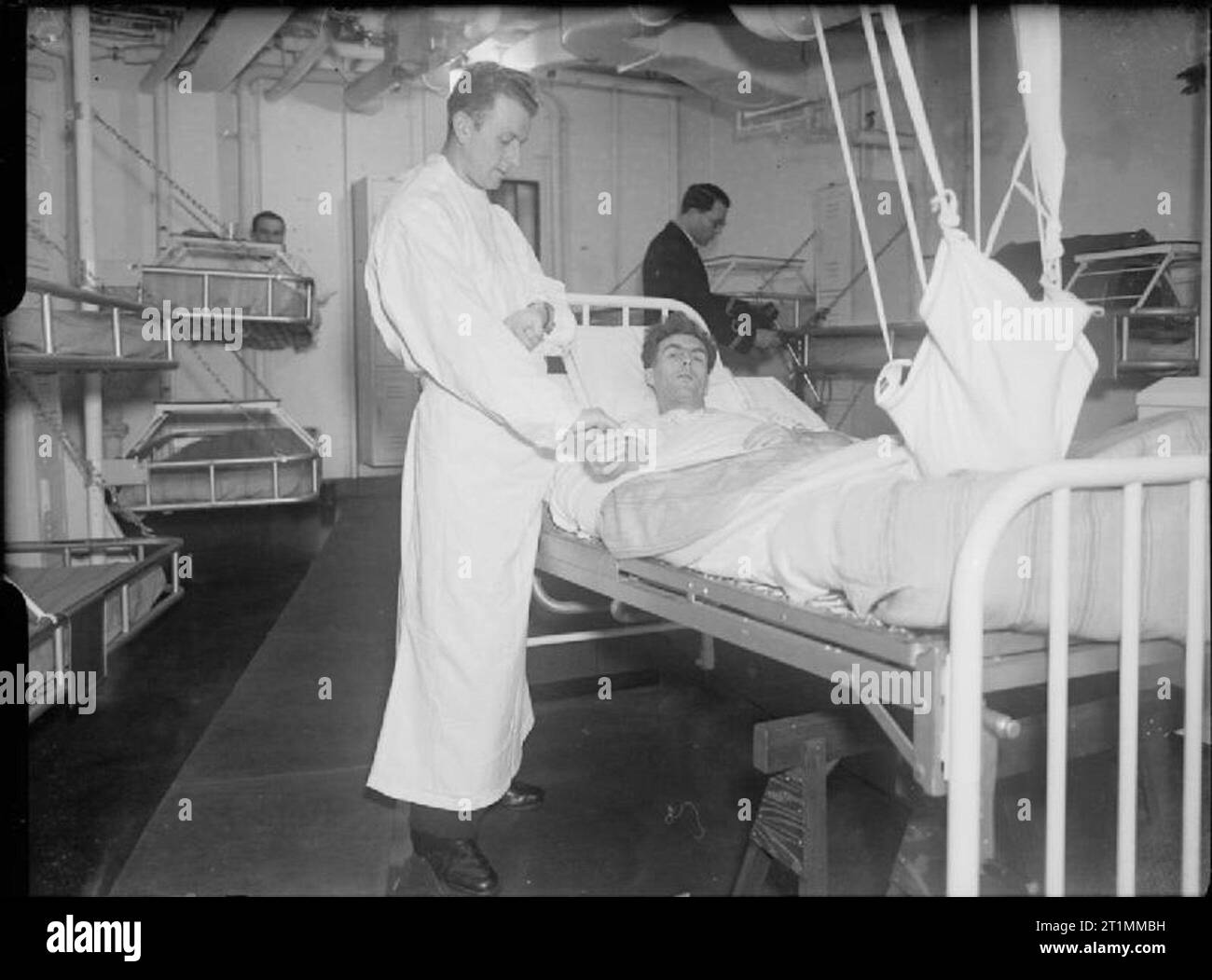 The Royal Navy during the Second World War One of the ratings of HMS TRACKER who had his foot injured when an aircraft ran over him, receiving the best of attention in the sick bay on board whilst the escort carrier is sailing in the North Atlantic. Stock Photo