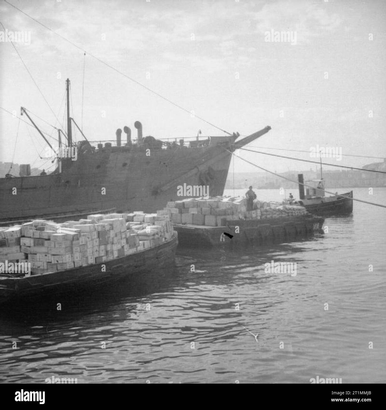 Operation Pedestal, August 1942. Operation Ceres: The unloading of supplies at Malta: lighters loaded with supplies lie alongside the Melbourne Star Stock Photo