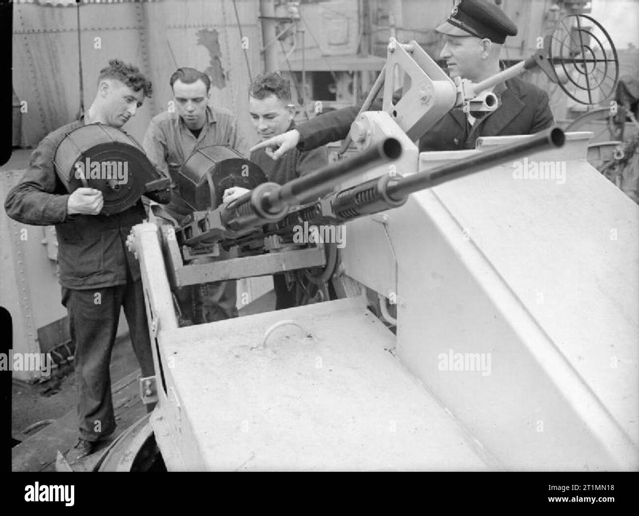 The Royal Navy during the Second World War 20 mm Oerlikon gunners of HMS STARLING on arrival at Liverpool. Left to right: Able Seaman Edward O'Malley, of Stockport, Cheshire (about to fix a fresh magazine of ammunition to the gun); Able Seaman John Smith of Islington, London; Able Seaman Edward Webster, of Dundee; and Petty Officer William G Barnshaw, of Callington, Cornwall. Stock Photo
