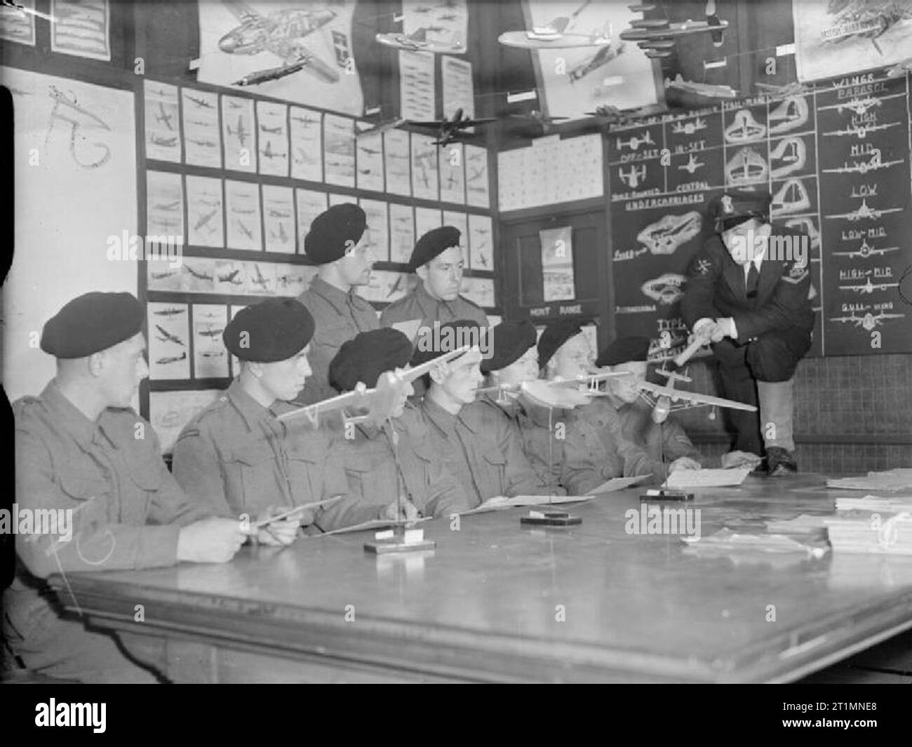 The Royal Navy during the Second World War Nine Royal Marines are given instruction in aircraft recognition by a Royal Navy Petty Officer. Models and illustrations of of different types of aircraft are on the tables and on the walls of the room. Stock Photo