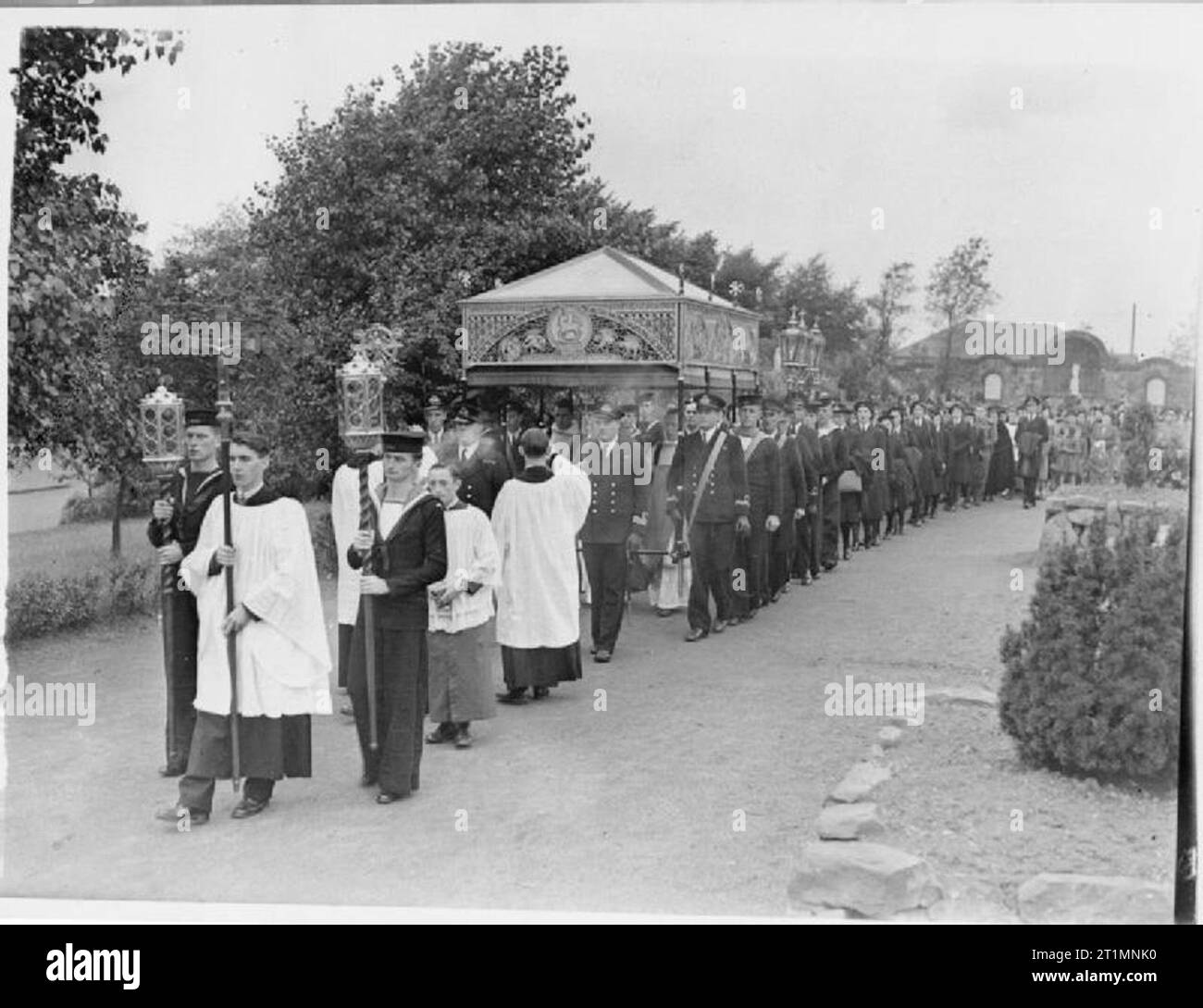 The Royal Navy during the Second World War Led by the Holy Cross and two sailors carrying candles, the procession nears the shrine at Carfin. Father John Wilson, a naval chaplain led more then a hundred Catholic naval officers, ratings and Wrens of HM ships and establishments in the east of Scotland in a pilgrimage to the Scottish Lourdes at Carfin. Officers and ratings carried the canopy of the Blessed Sacrament, held by Father W Tindall-Atkinson in procession to the grotto, and before Our Lady's shrine he gave benediction, and finally blessed the congregation of 2,000 people. Stock Photo