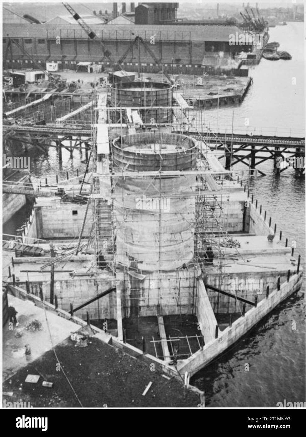 The Royal Navy during the Second World War Maunsell Sea forts in the Thames Estuary: In the dock basin the twin towers of a sea fort to be used in the Thames Estuary are rapidly rising from the floating pontoon. A pre-assembled spot welded cage is hoisted into position, and the concrete is poured between a permanent wooden inner wall and an outer steel shell. Then the steel shell is moved up and the next cast is made. These secret forts were an effective defence against attacks by sea and air on the estuary. Stock Photo